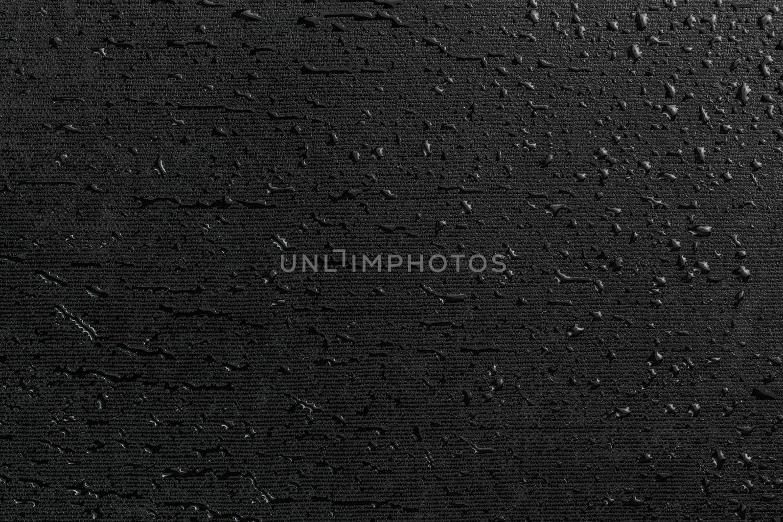 water drops on black flat rubber surface dark macro background