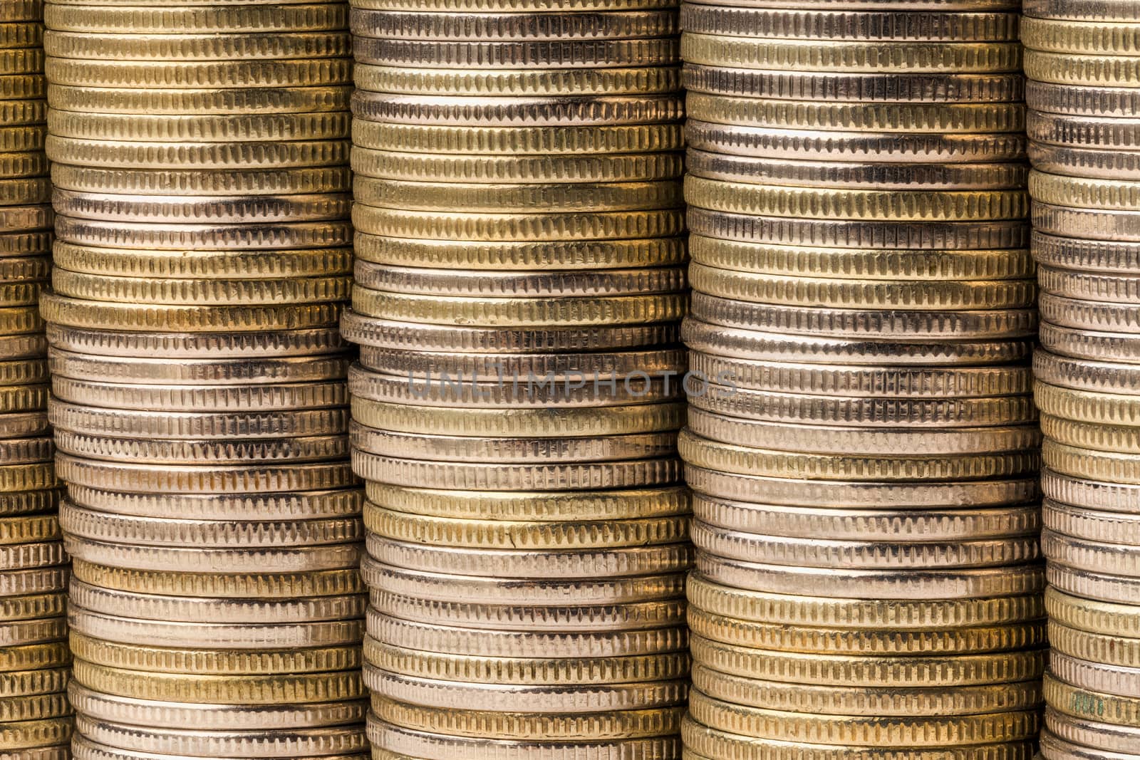 Five equal stacks of coins merged in one solid wall macro background.