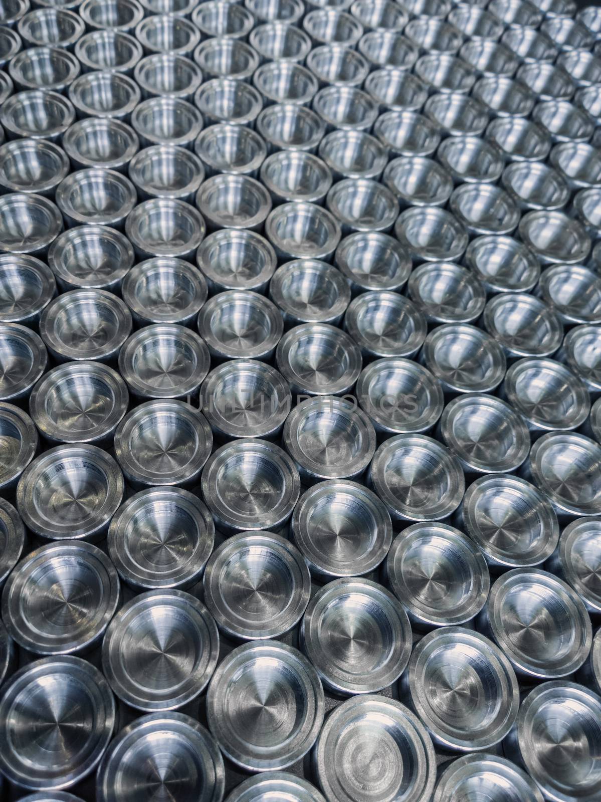Shiny metal parts after cnc turning, on flat surface selective focus composition background.