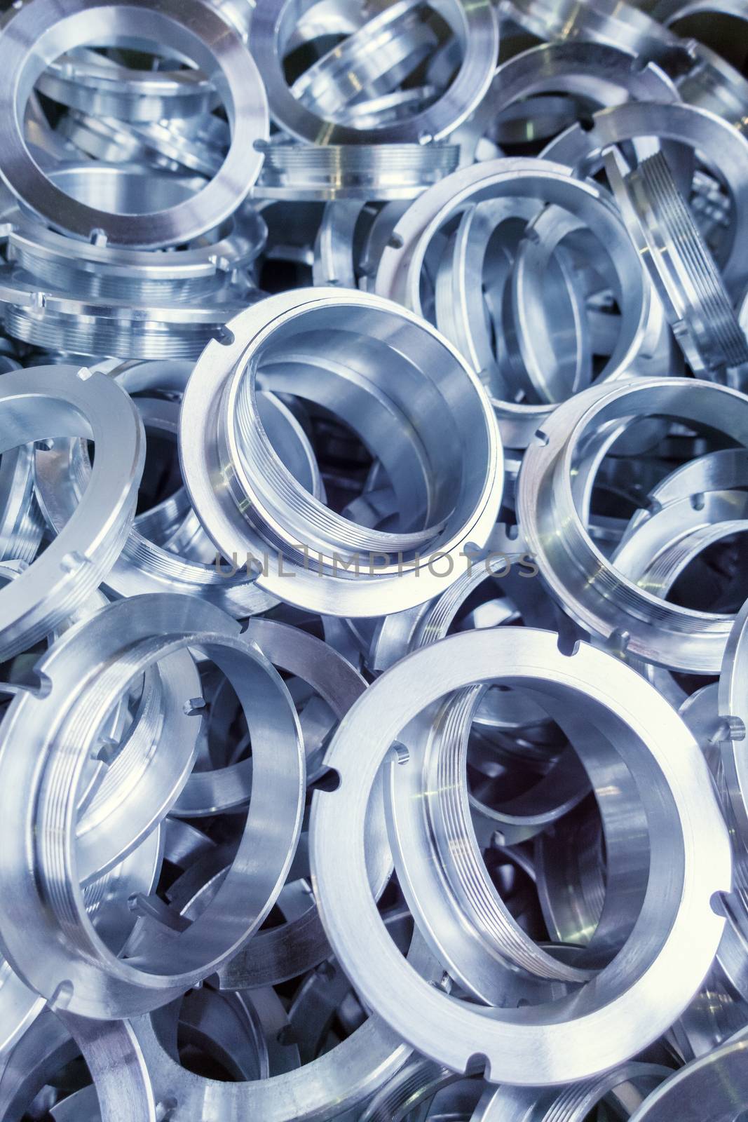 a batch of machined shiny metal parts with selective focus.