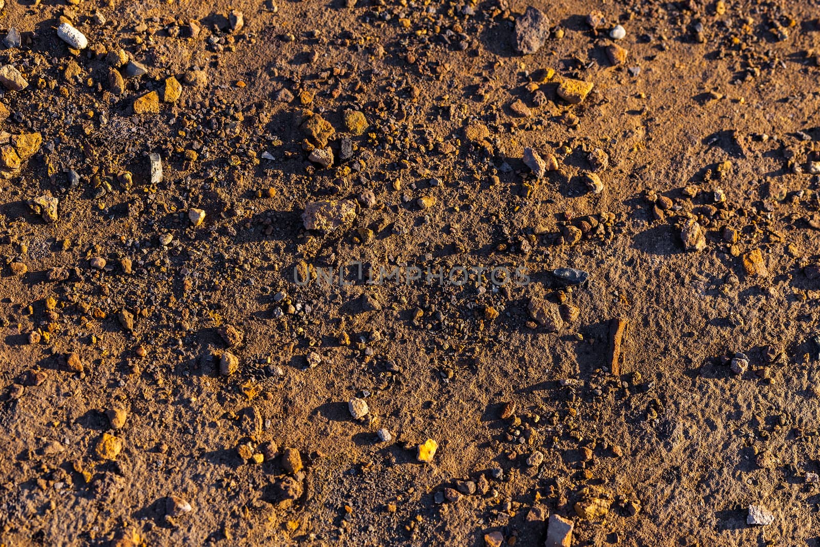 abstract dry mud background with small rocks and selective focus.