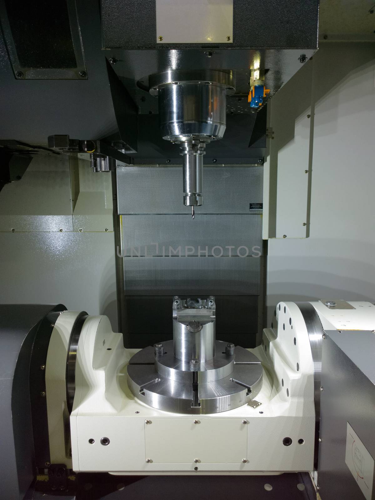 The five-axis Computer Numerical Control CNC machine waiting for stock change.