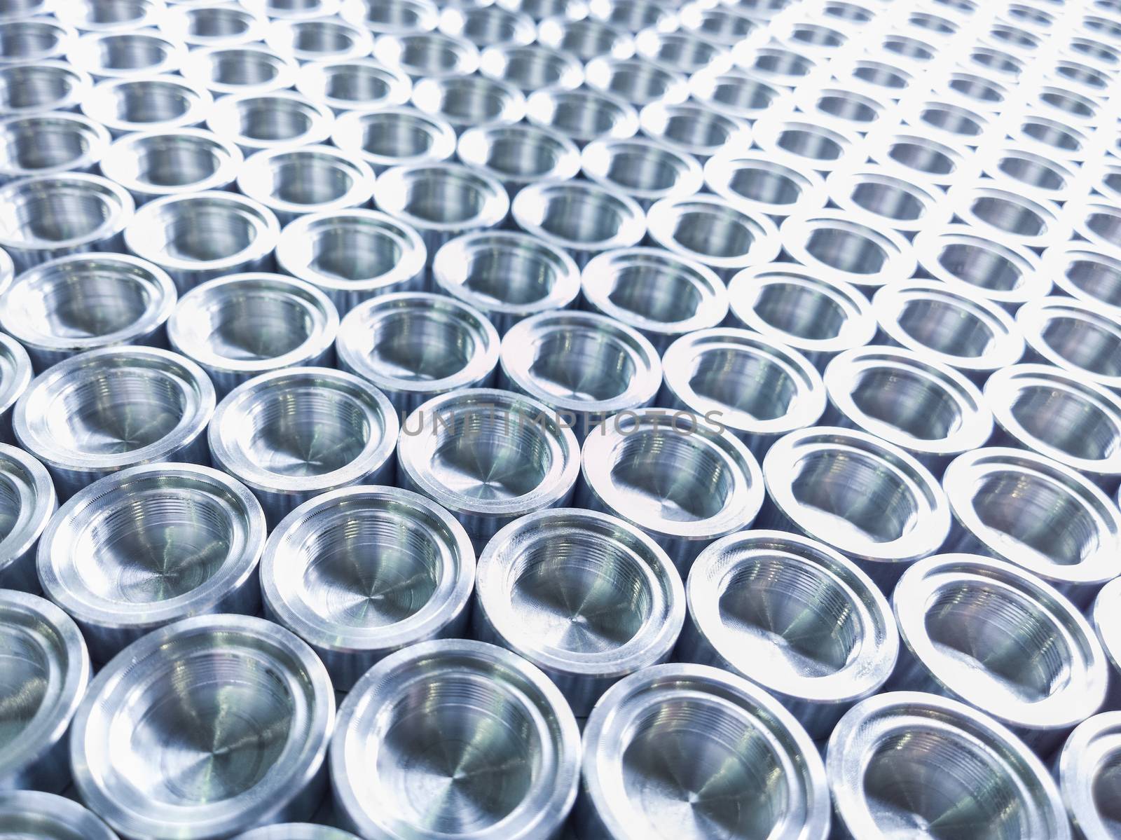 Shiny metal parts after cnc turning, on flat surface selective focus composition background.
