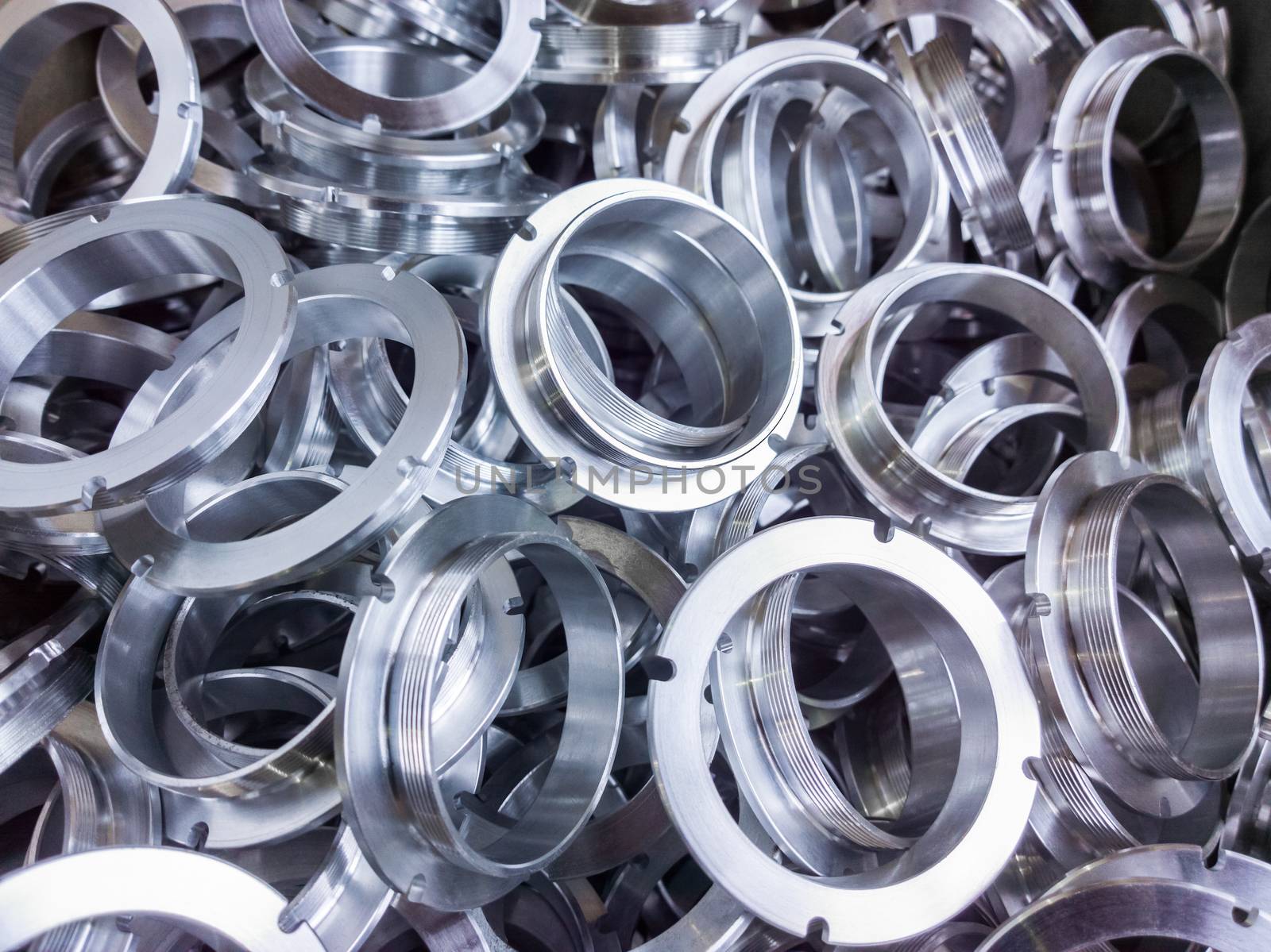 a batch of machined shiny aluminium parts with selective focus.