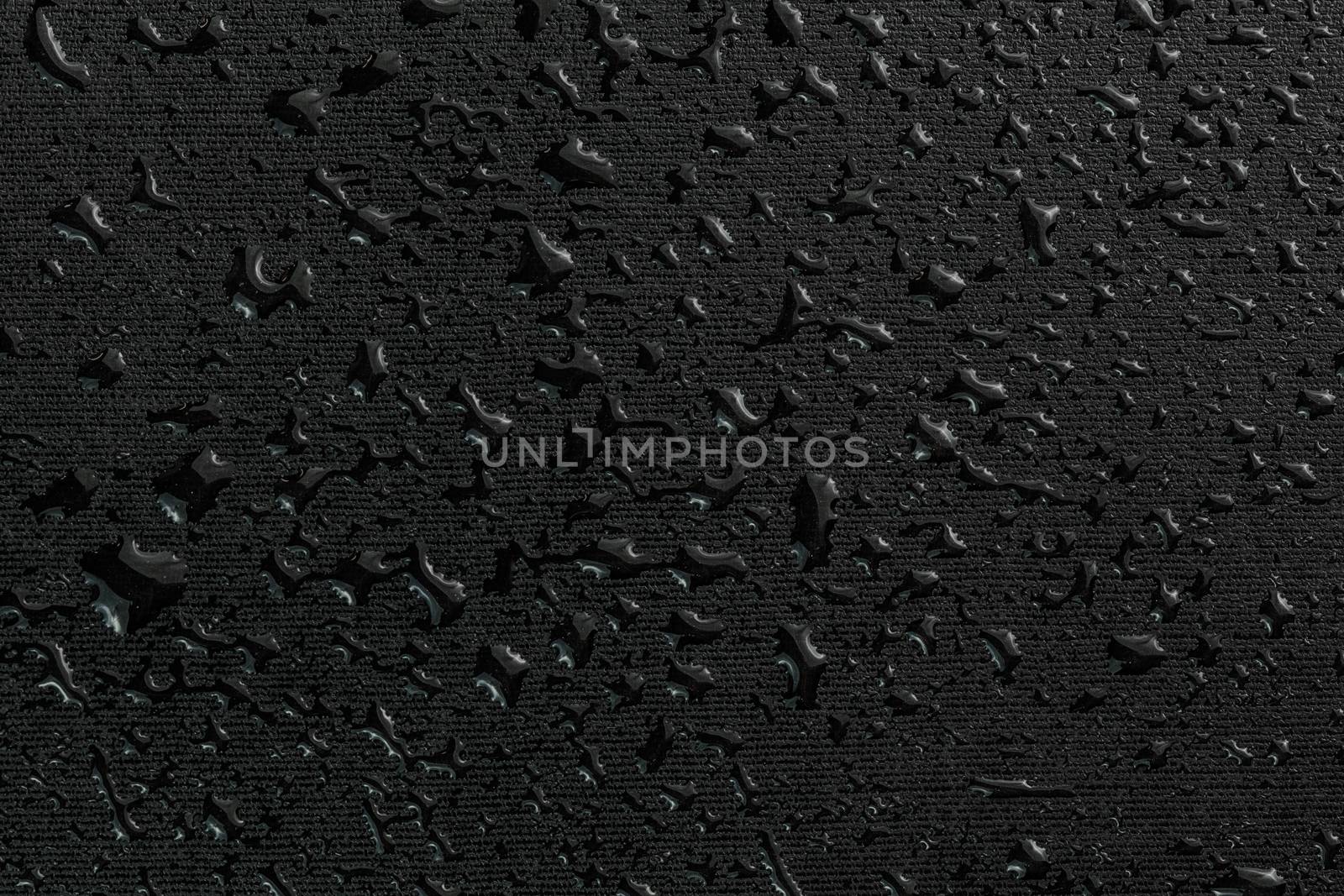 water drops on black flat rubber surface dark macro background