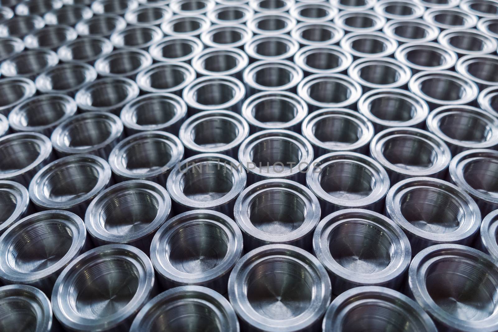 Shiny metal parts after cnc turning, on flat surface selective focus composition background.