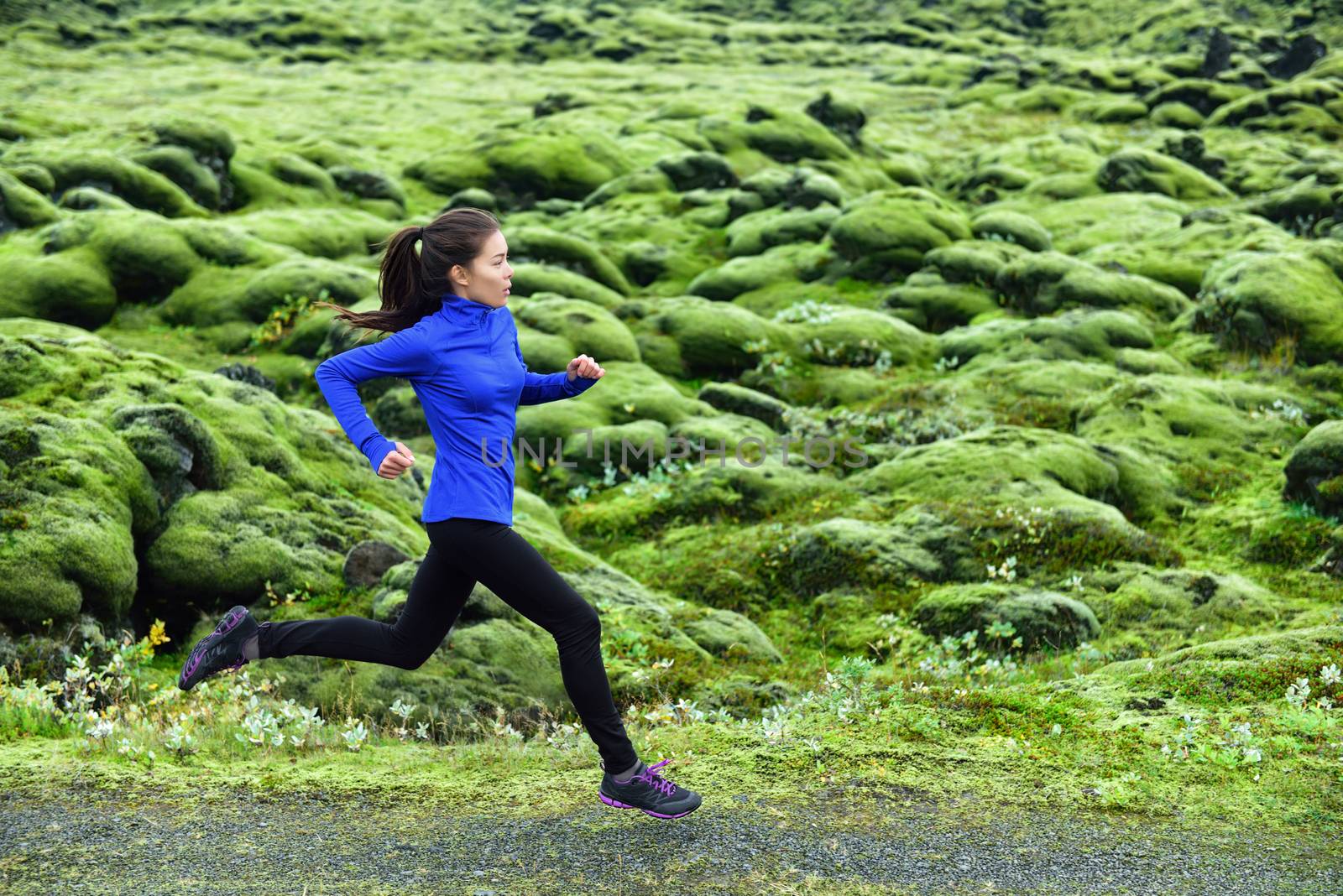 Running woman. Young female runner jogging and trail running on footpath. Woman is exercising in nature.