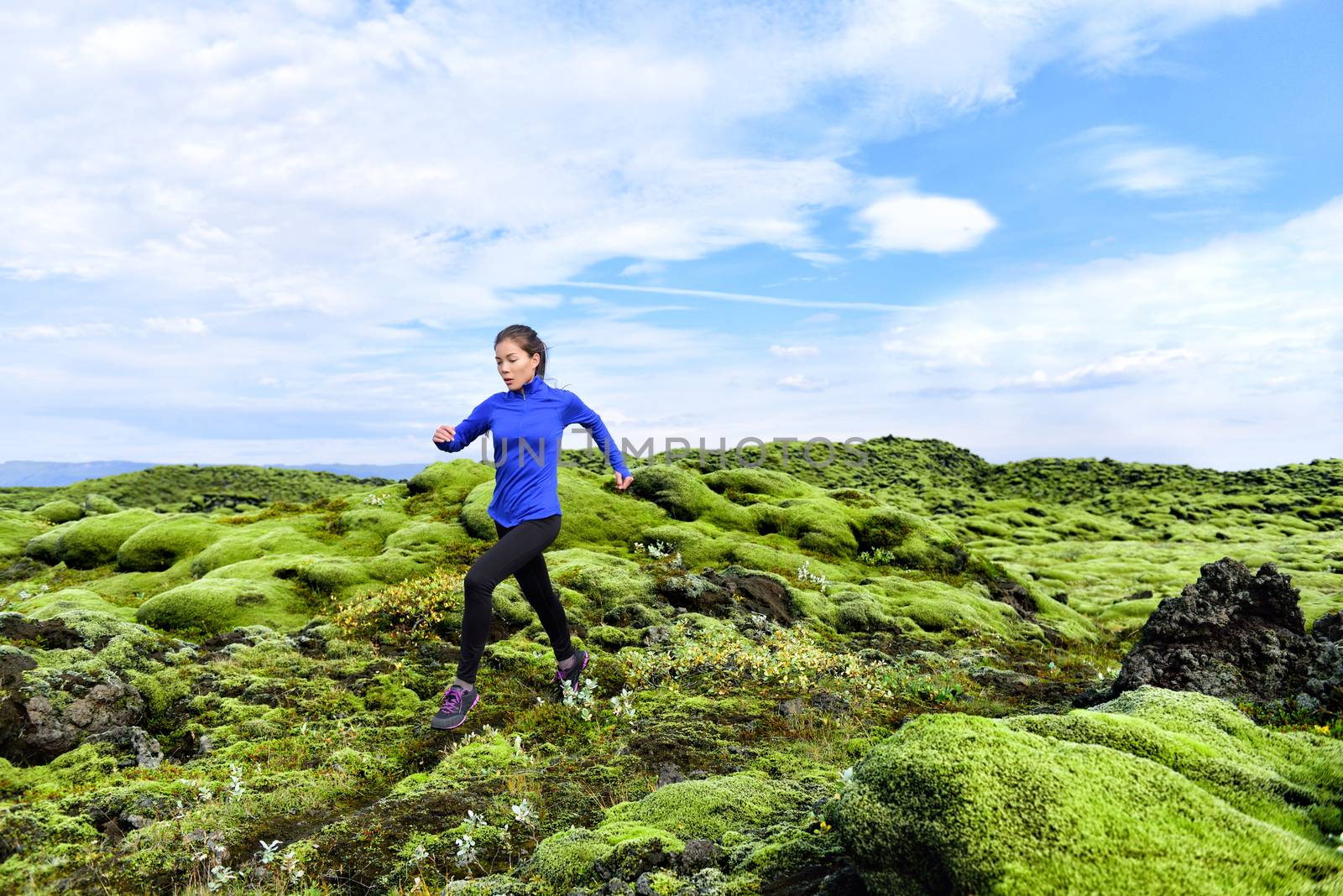 Running woman athlete trail runner - running woman exercising. Fit female sport fitness model training jogging outdoors living healthy lifestyle in beautiful nature, Iceland.