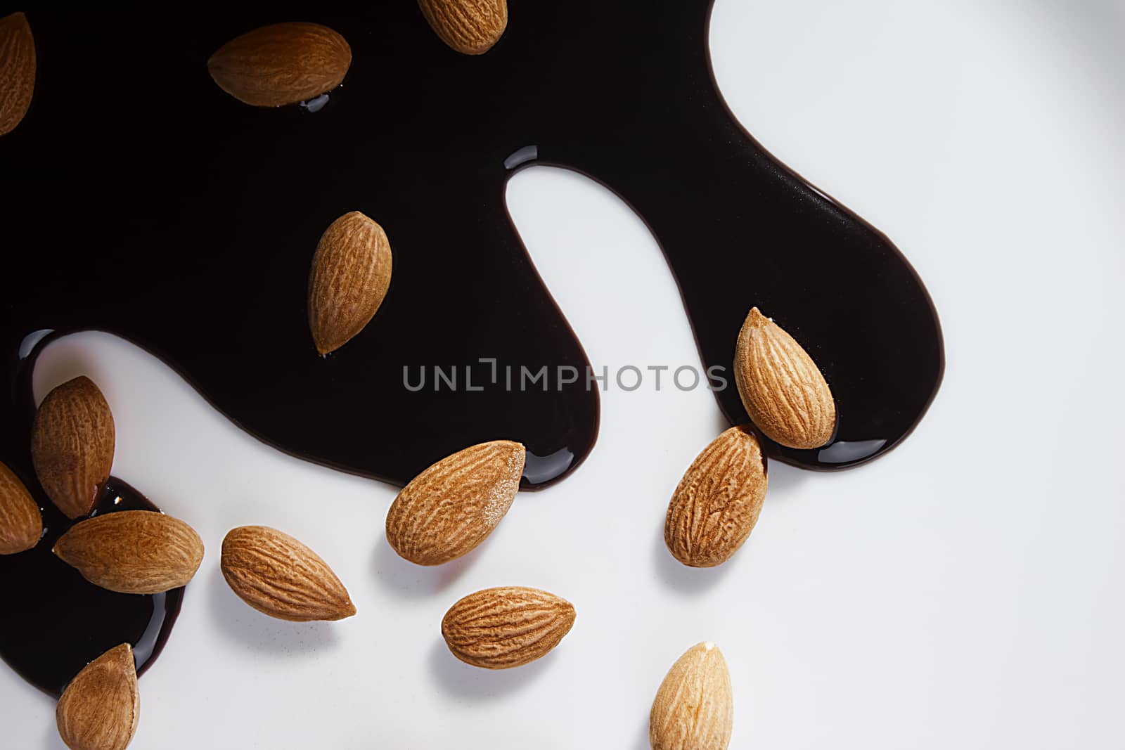 Almonds and melted chocolate on a white background