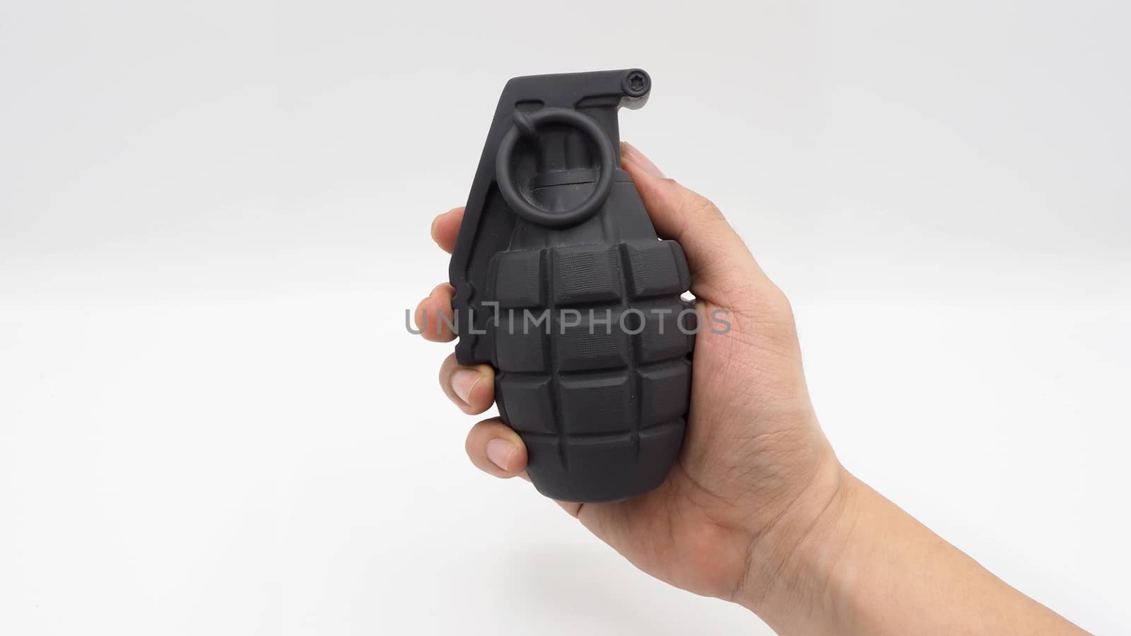 Man hand and military bomb plastic model toy and white background.