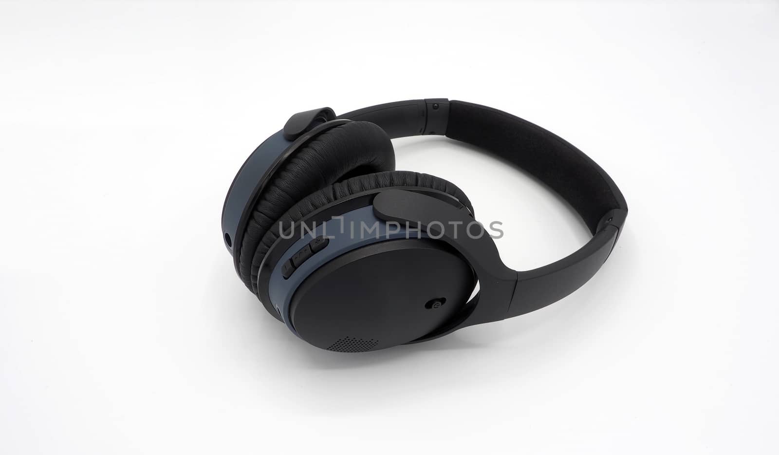 Black wireless headphone around ears and white background and isolated.