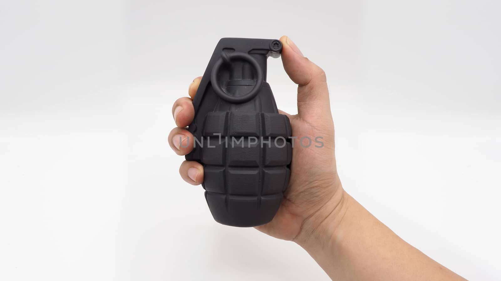 Man hand and military bomb plastic model toy. by gnepphoto