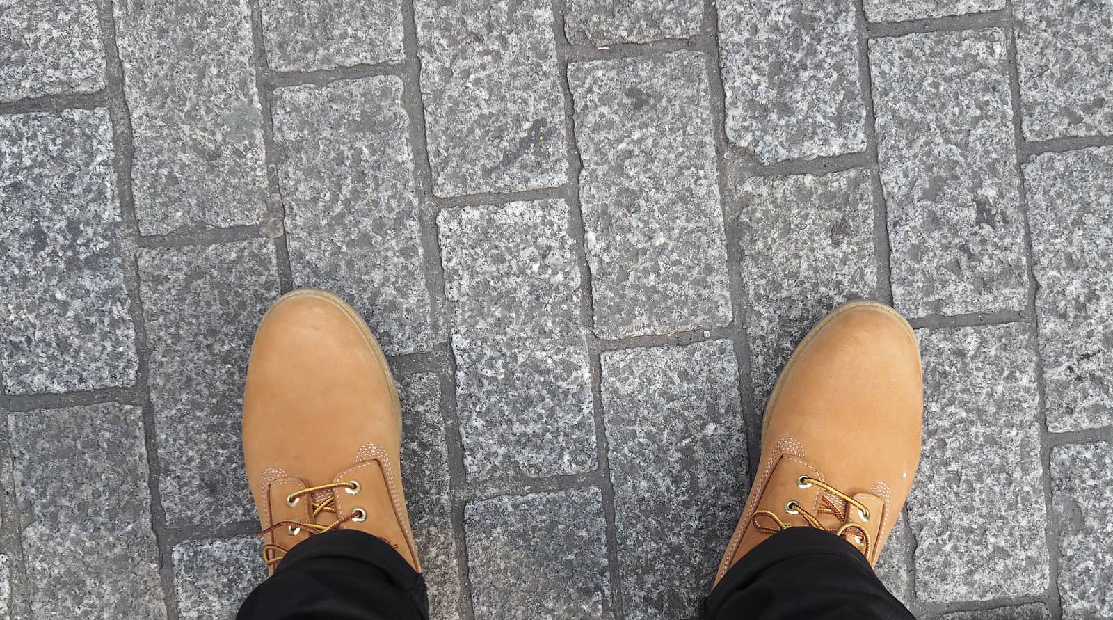 Man yellow boot shoe top view and stone floor.