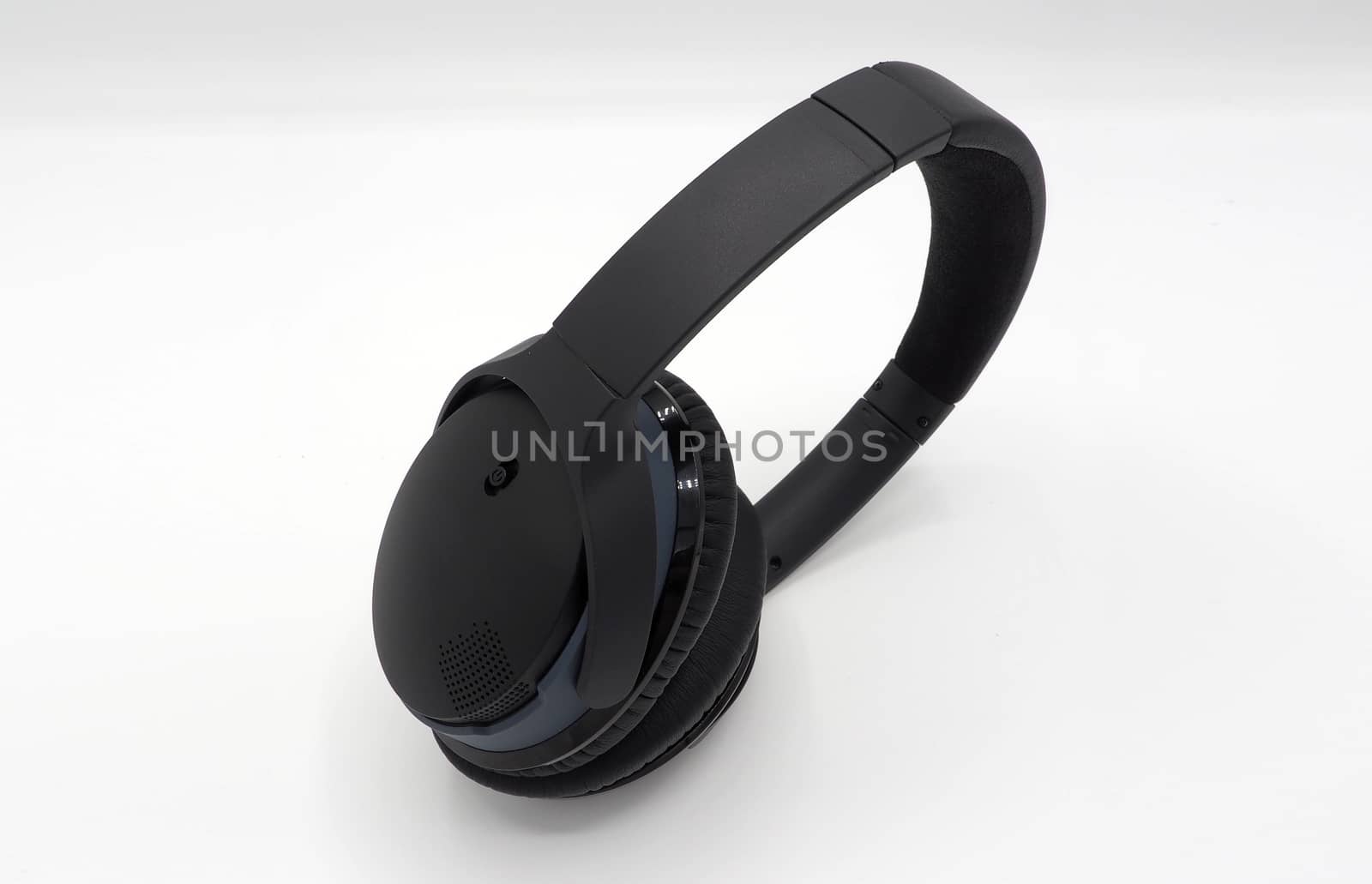 Black wireless headphone around ears and white background and isolated.