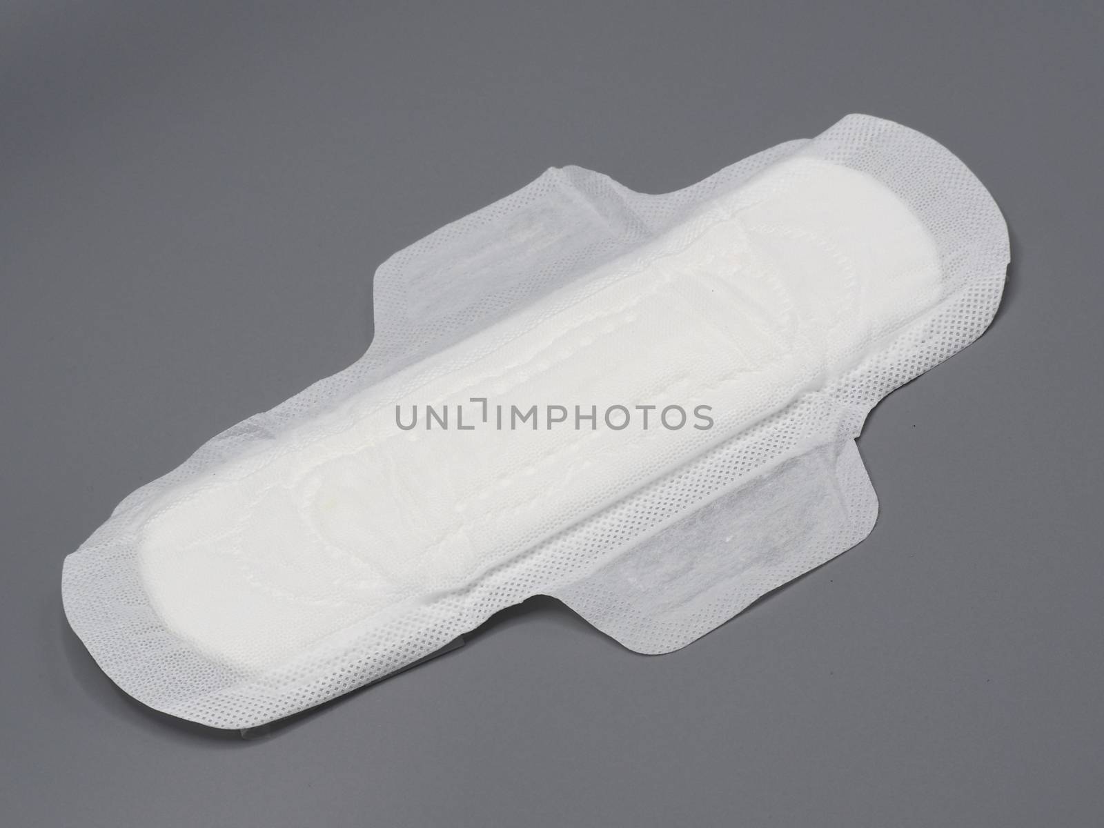 Hygenic organic cotton soft and comfort sanitary napkin pad for woman and grey background.