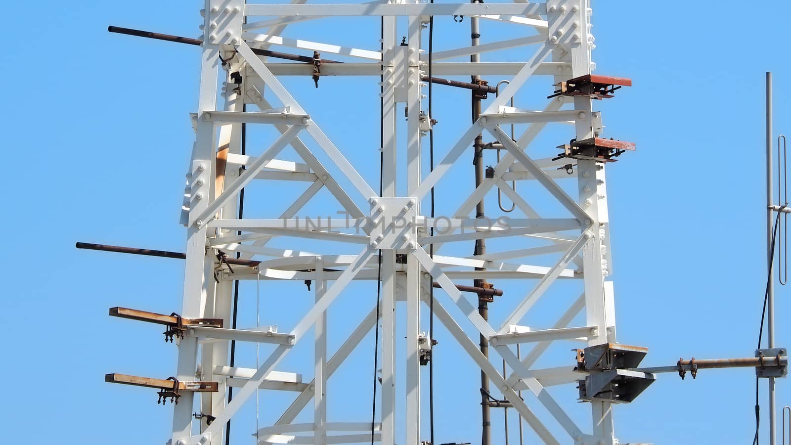 Telecommunication tower closeup and white color and sky.