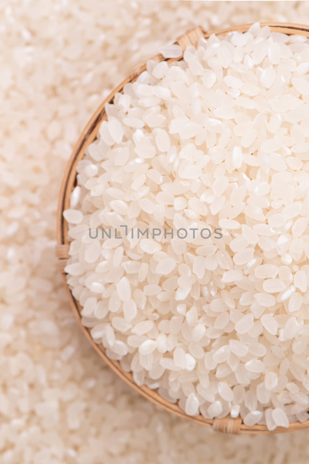 Raw rice in a bowl and full frame in the white background table, top view overhead shot, close up