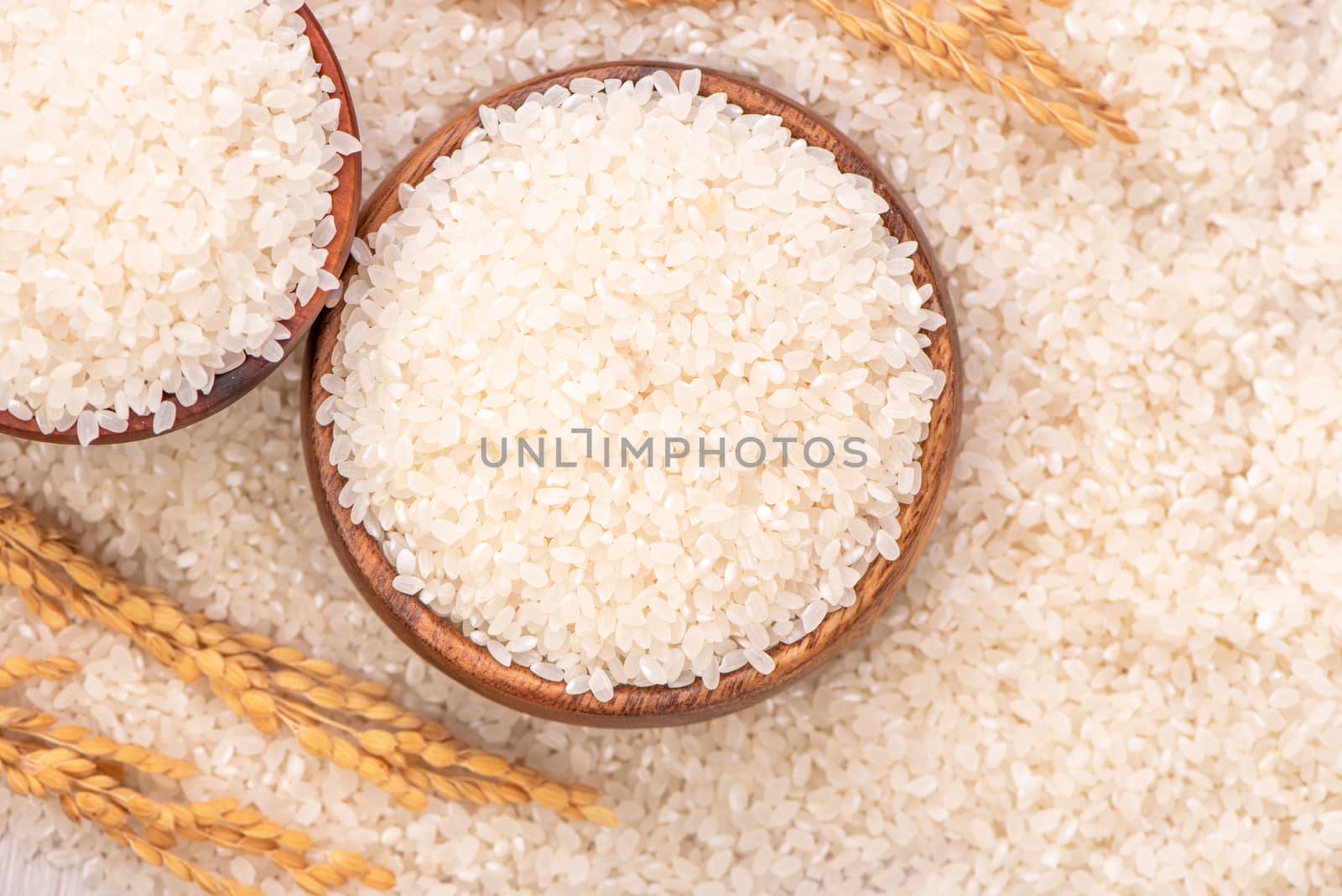 Raw rice in a bowl and full frame in the white background table, top view overhead shot, close up