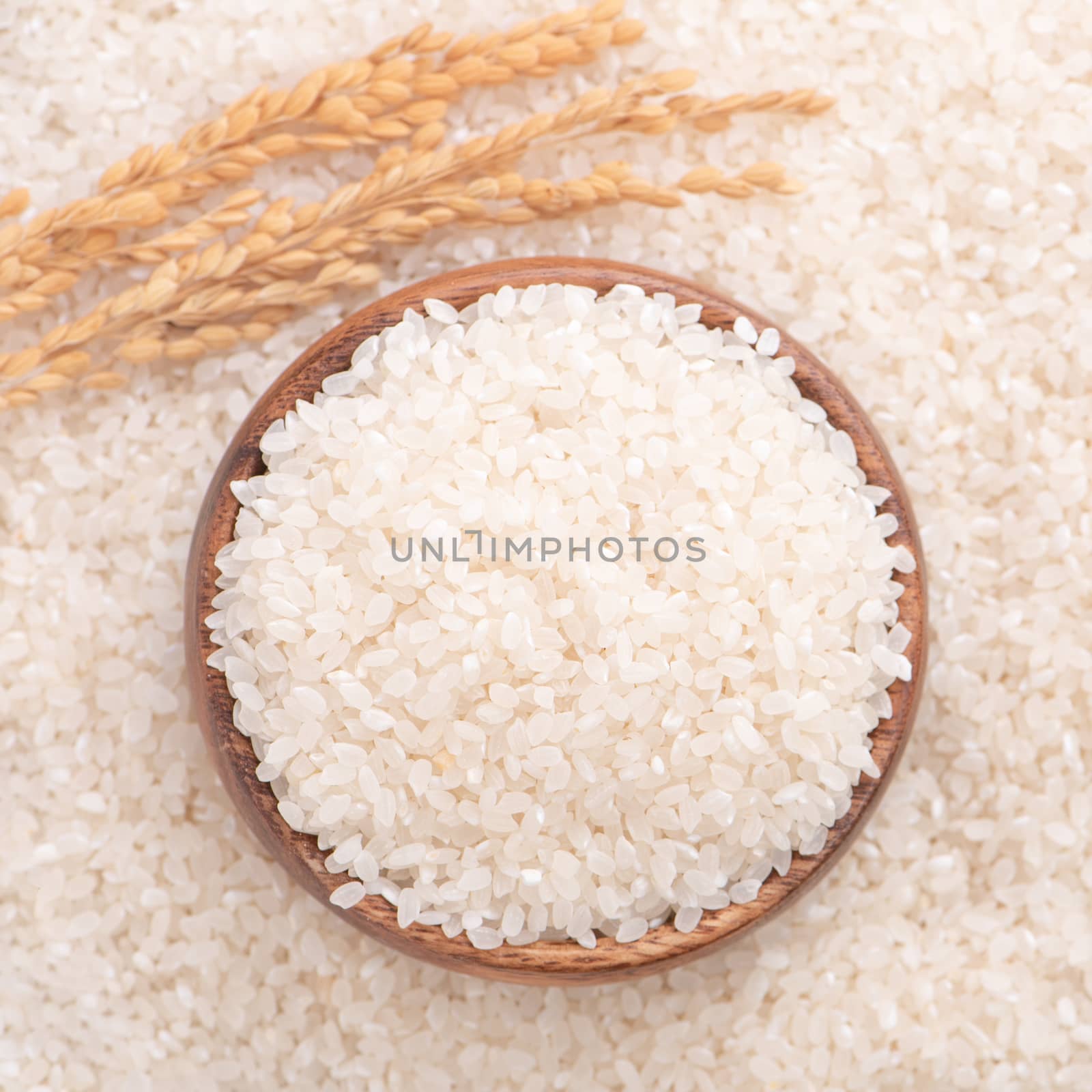 Raw rice in a bowl and full frame in the white background table, top view overhead shot, close up