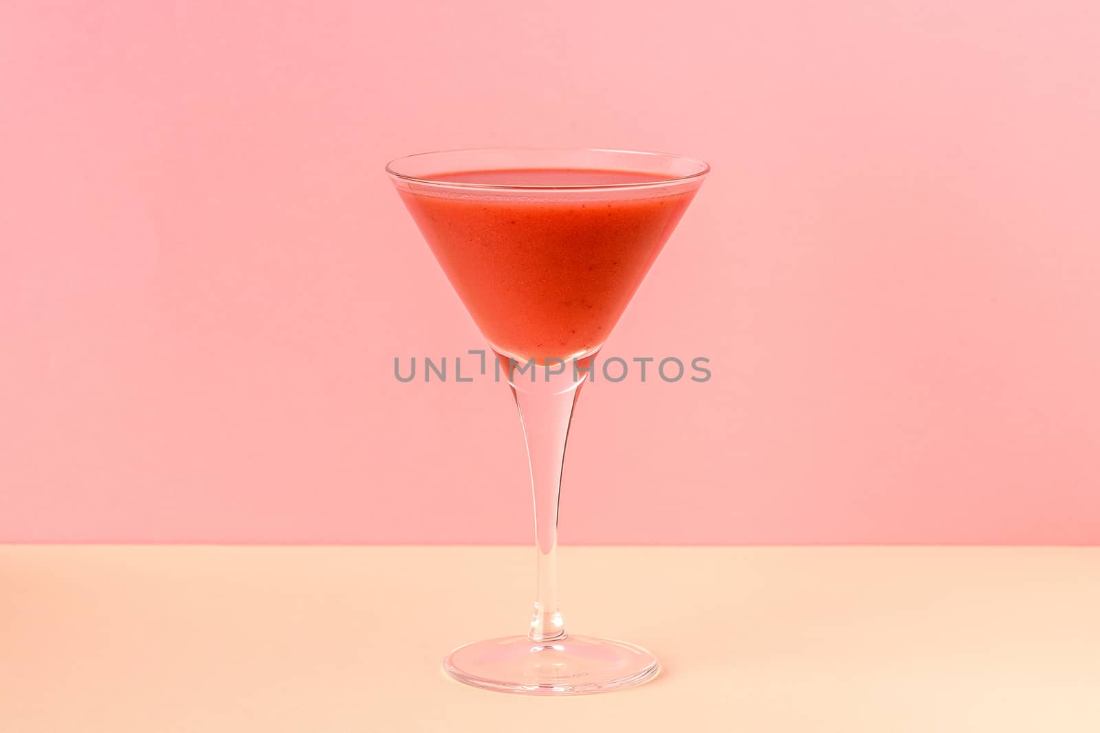 Strawberry smoothie cup on a pink and yellow background. Minimalist image.