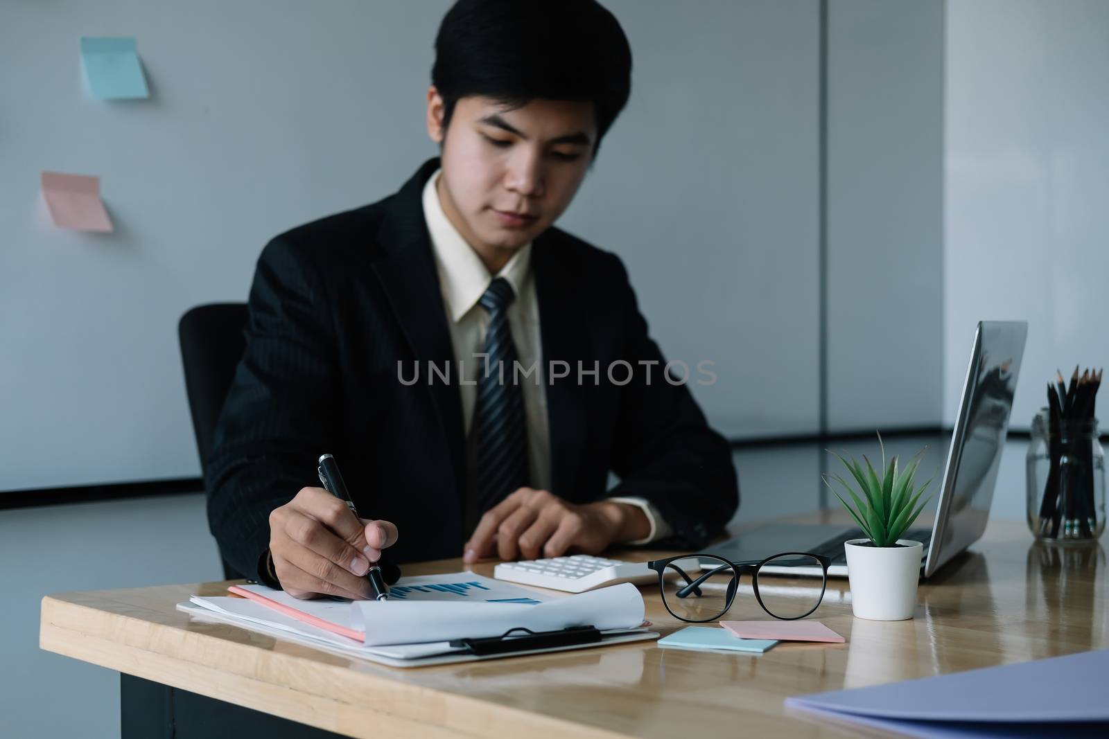 Asian businessman working with laptop computer for finance at office.