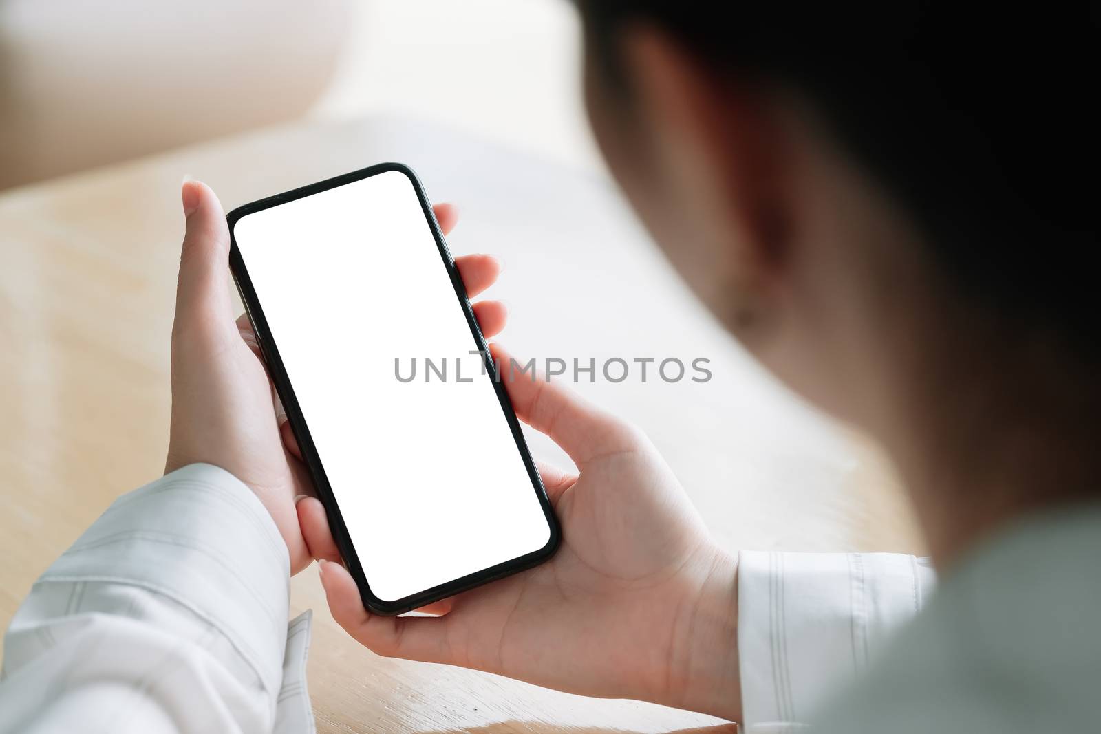 Top view Woman sitting and holding blank screen mock up mobile phone by nateemee