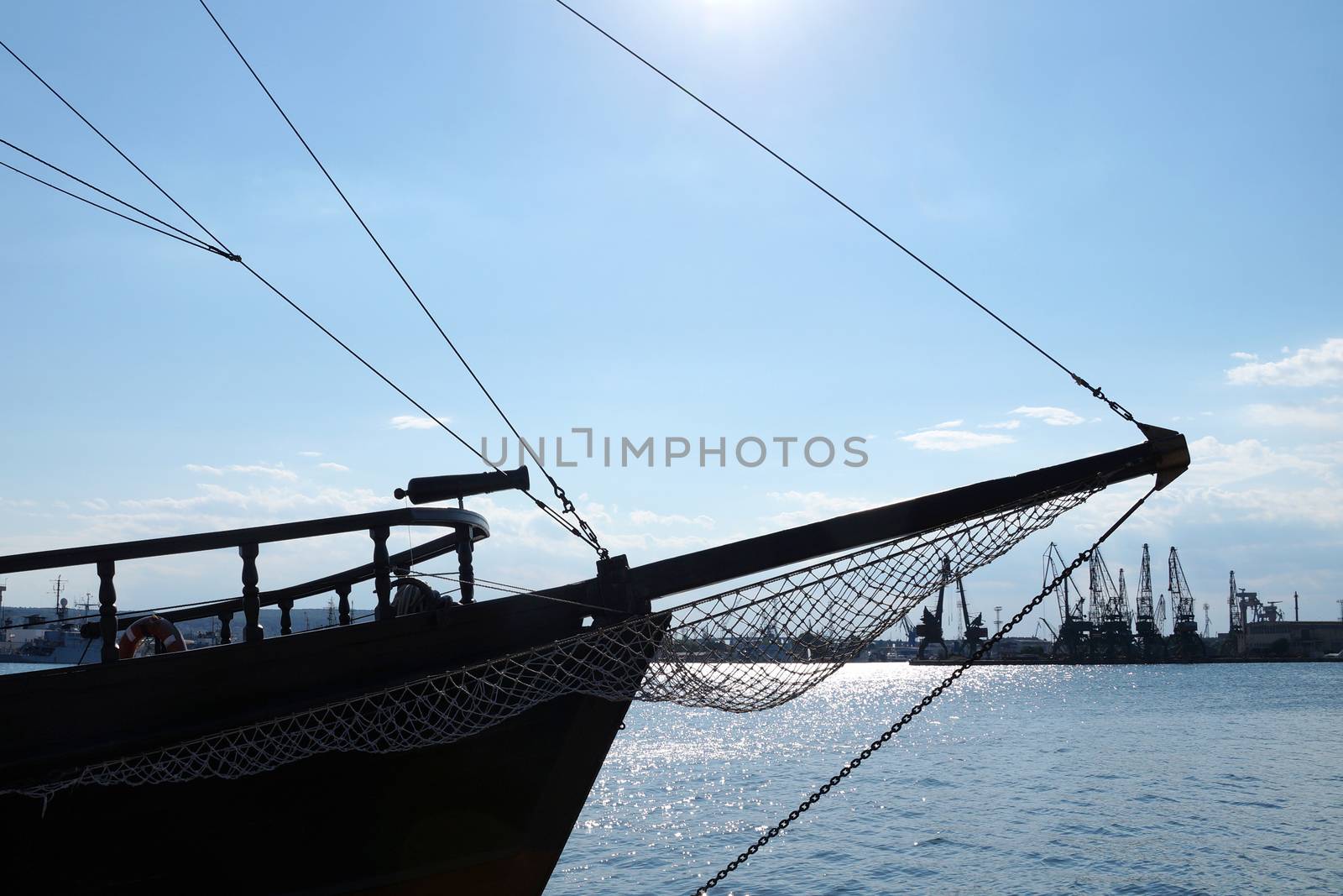 the bow of an old ship against a blue sunset sky.