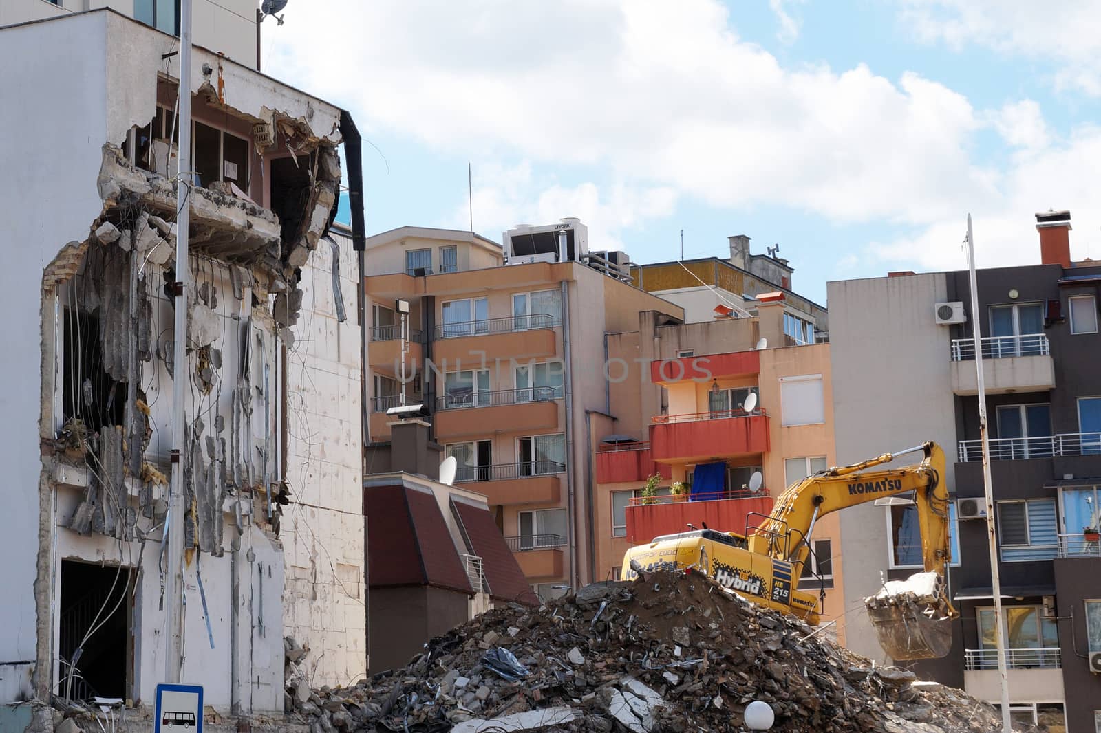 excavator demolishes a house in a residential area by Annado