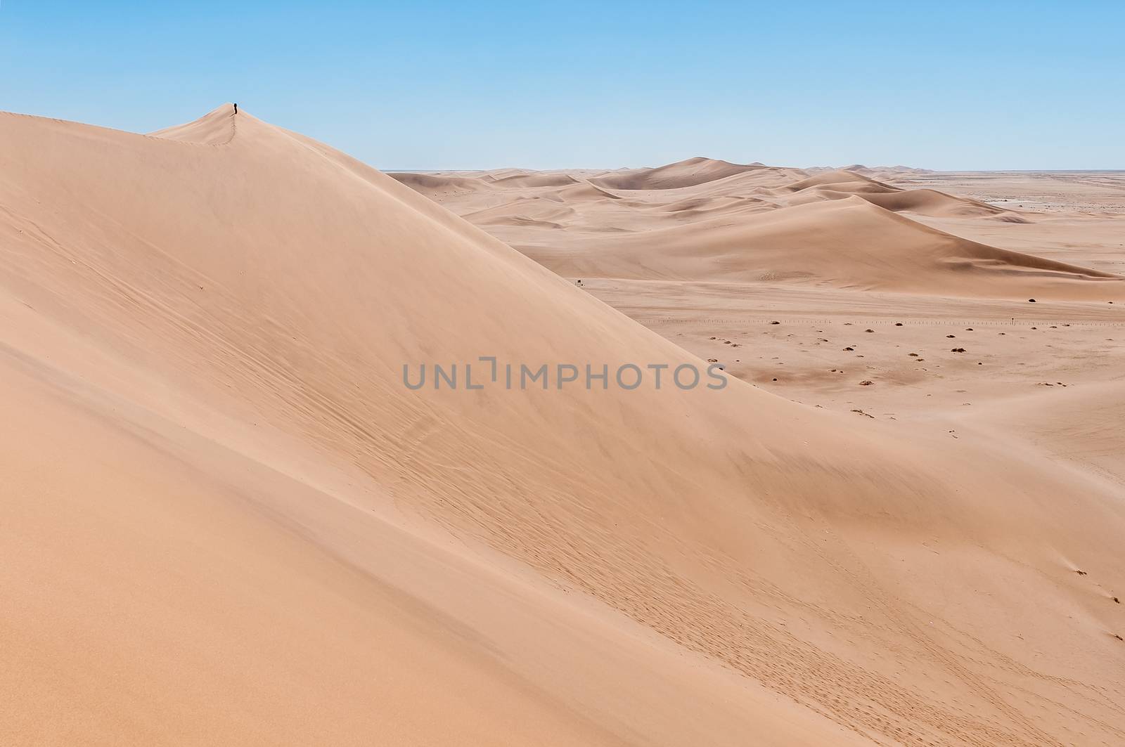 A person is visible on Dune 7 at Walvis Bay on the Atlantic Ocean coast of Namibia
