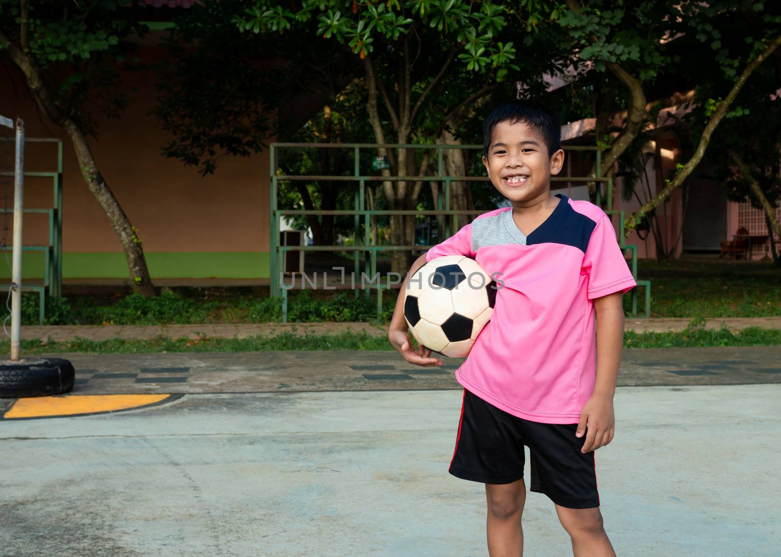 Little boy holds soccer ball.