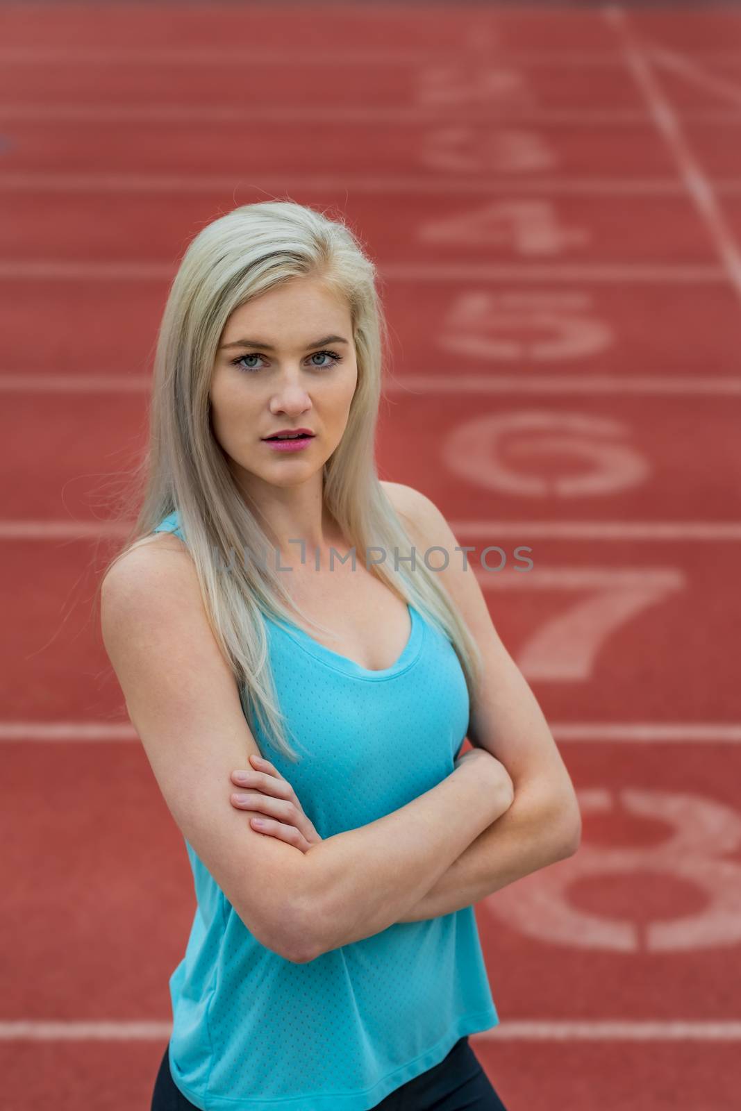 A beautiful young college athlete prepares herself for a track meet at a local university