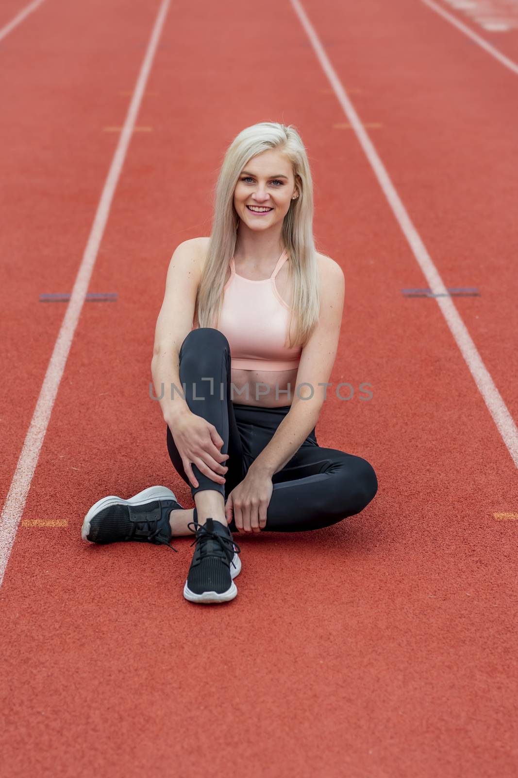 A beautiful young college athlete prepares herself for a track meet at a local university