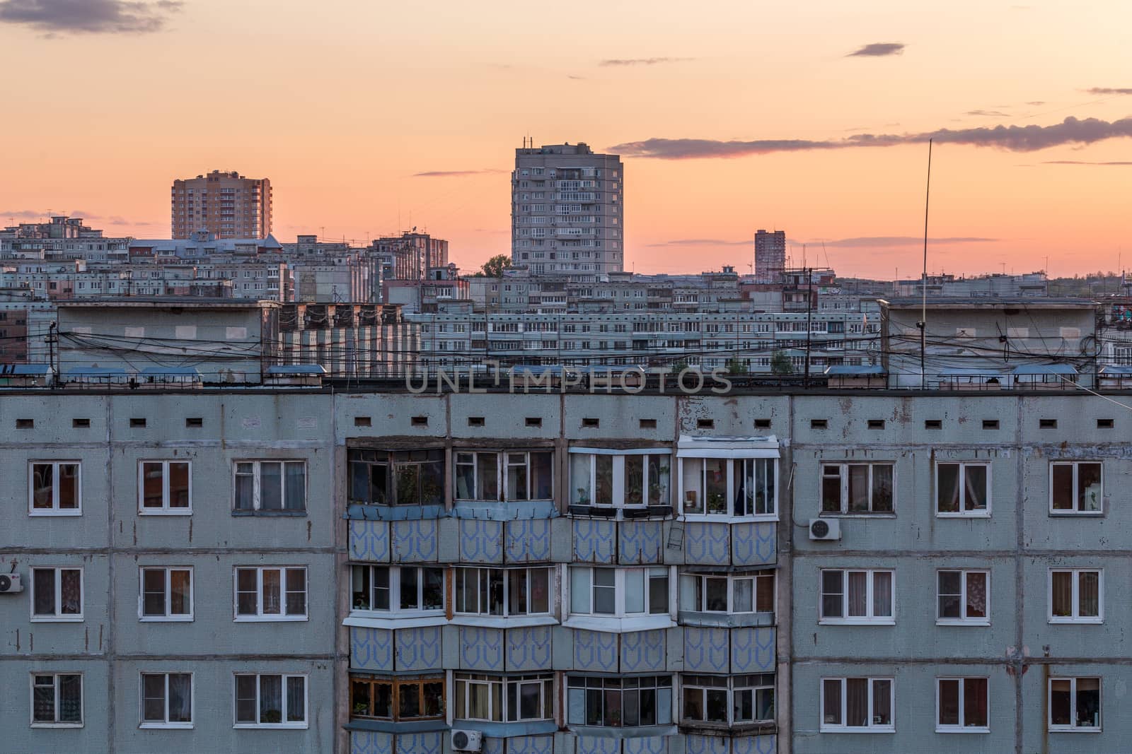 Windows, roofs and facade of an apartment building in Russia at evening
