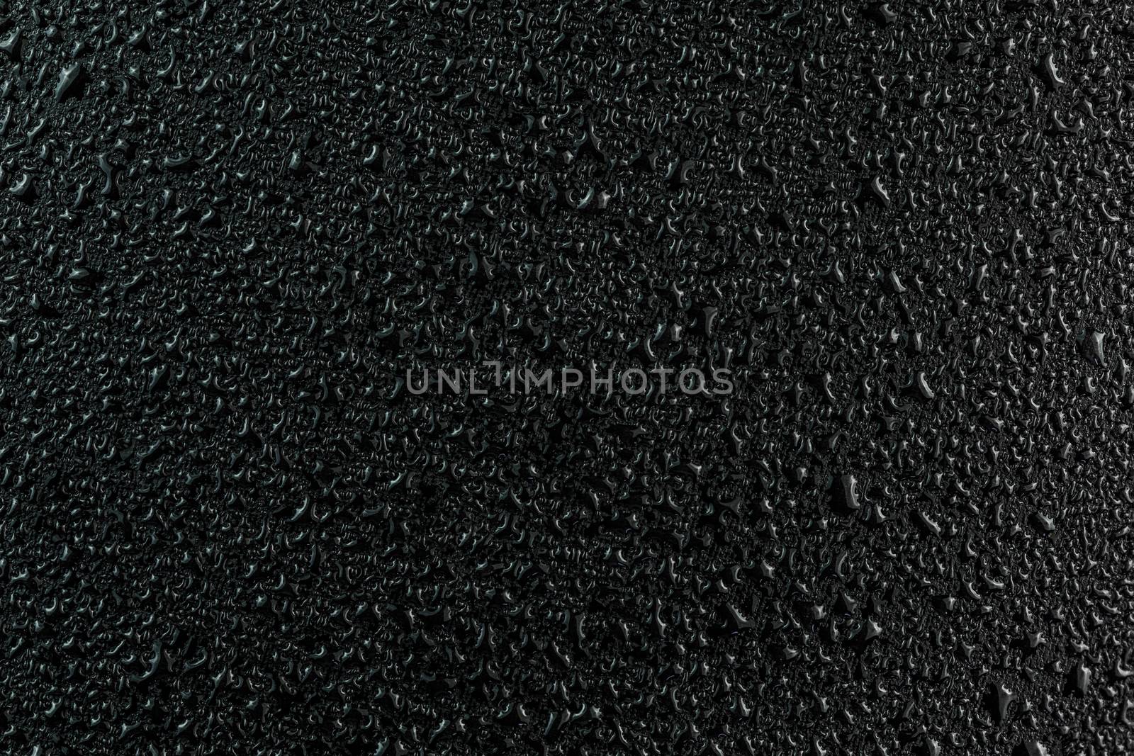 water drops on flat black rubber surface dark macro background