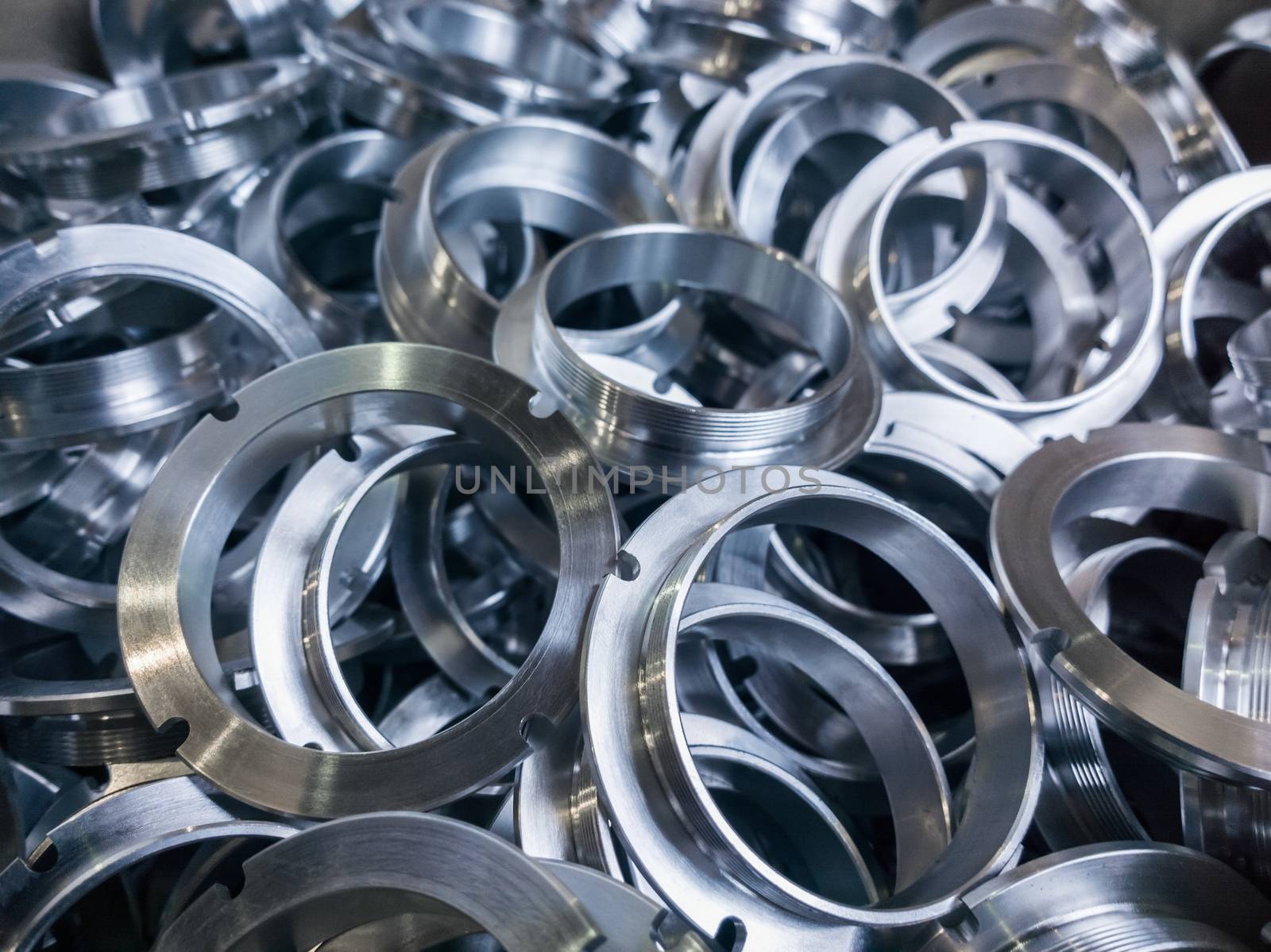 a batch of machined shiny metal parts with selective focus.