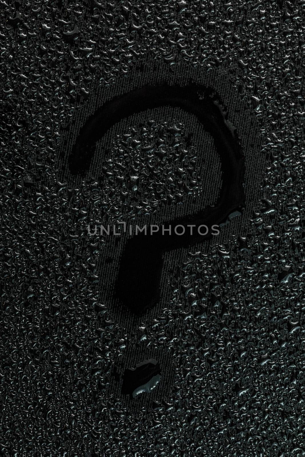 water drops on flat black rubber surface with the handwritten inscription - question mark