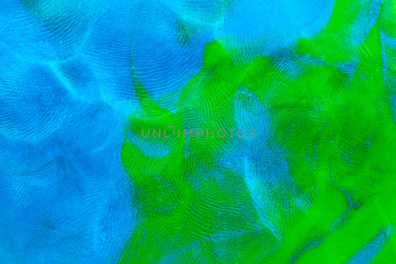 Mixed blue-green flat plastilin texture with distinct finger prints. Small dust particles on bumpy surface.