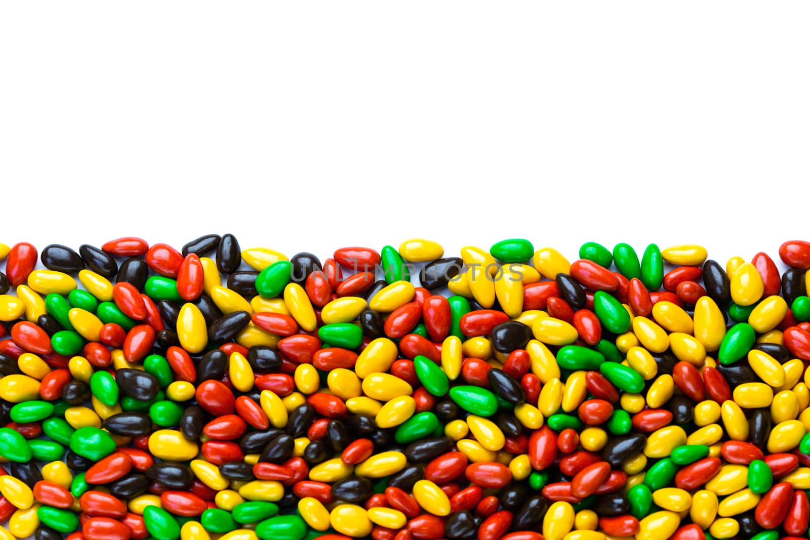 hundreds of small gloss glazed sunflower seeds multicolor flat background with selective focus with isolated side on white backgroud