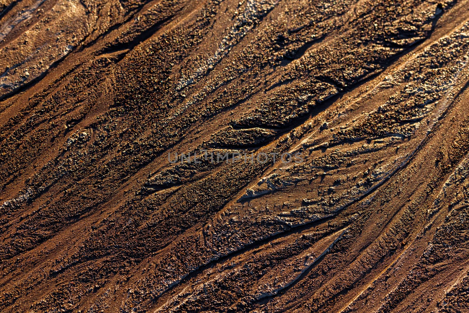 abstract mud background with water washout trails and selective focus.