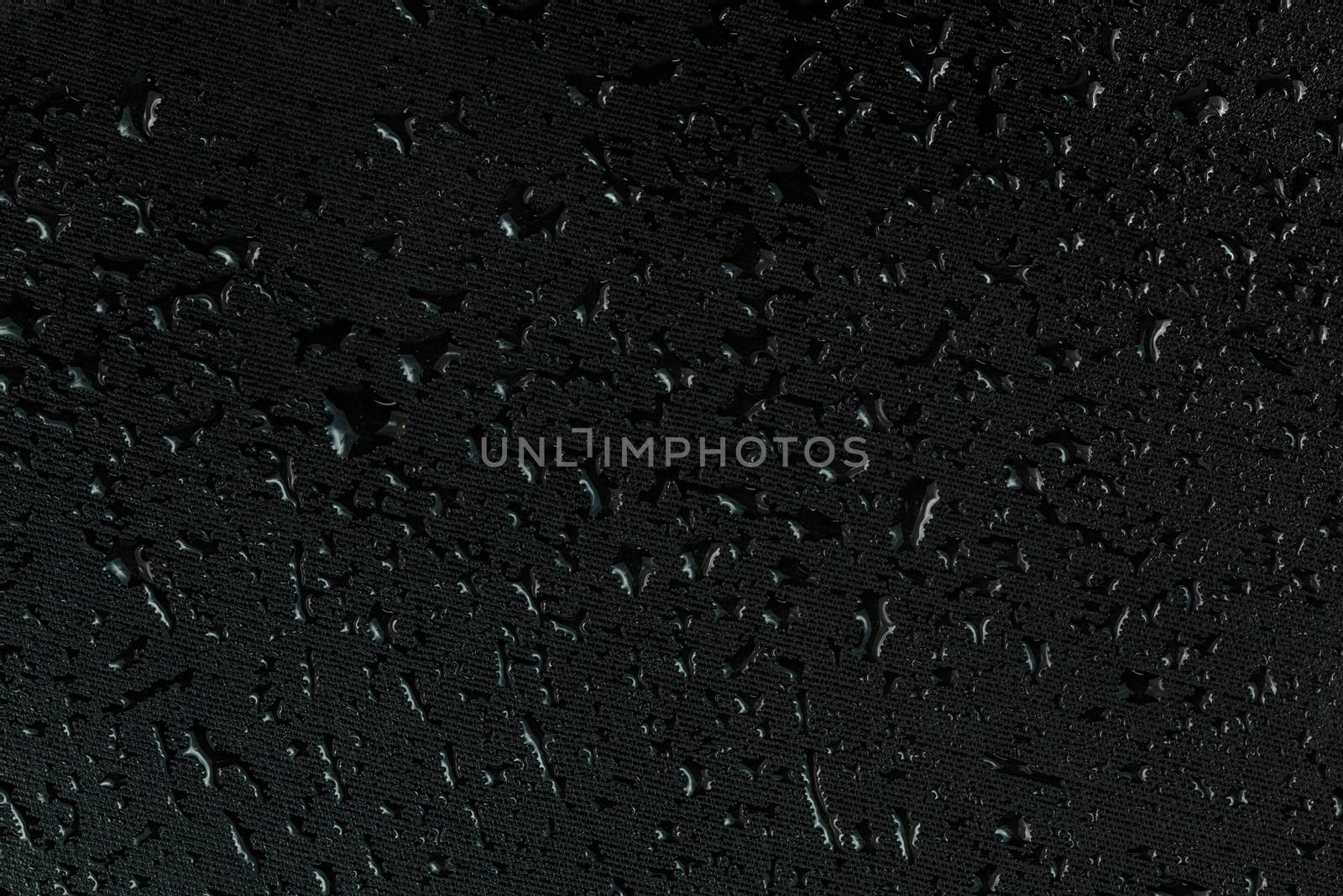 water drops on flat black rubber surface dark macro background