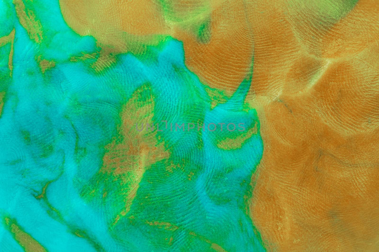 Mixed brown-green flat plastilin texture with distinct finger prints. Small dust particles on bumpy surface.