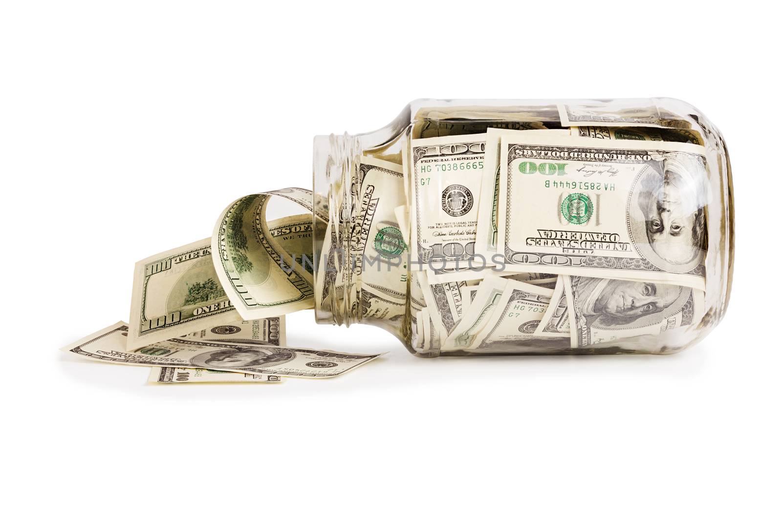 glass jar full of hundred us dollar banknotes laying on side - isolated on white background
