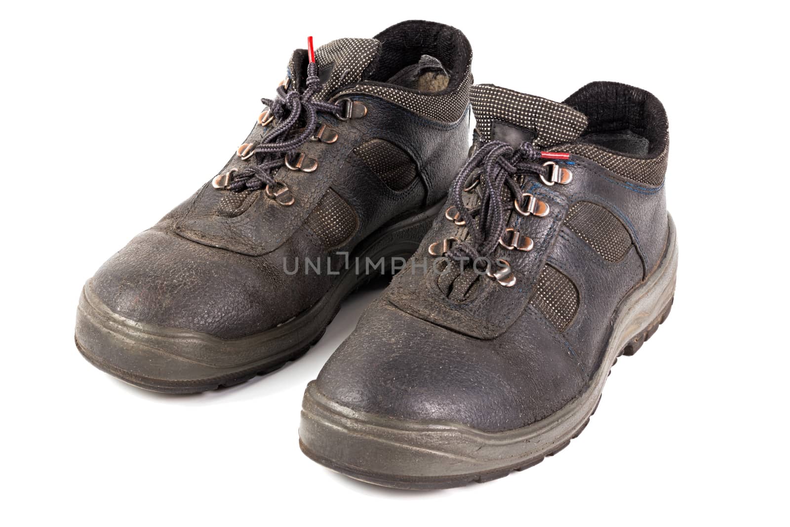 a pair of used blue leather work shoes with fabric incuts isolated on white background.