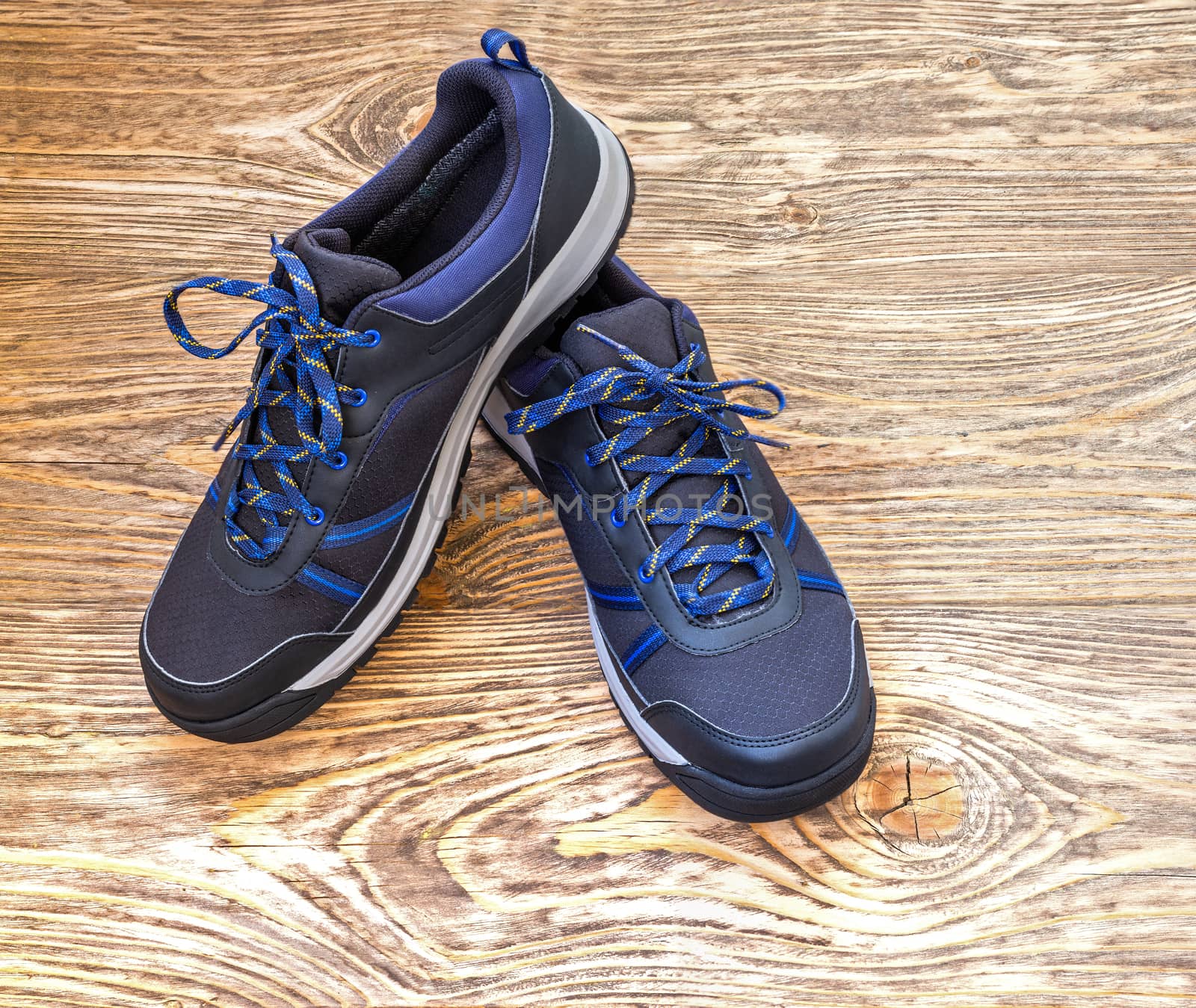black and blue outdoor empty clean lightweight waterproof sneakers on wooden surface