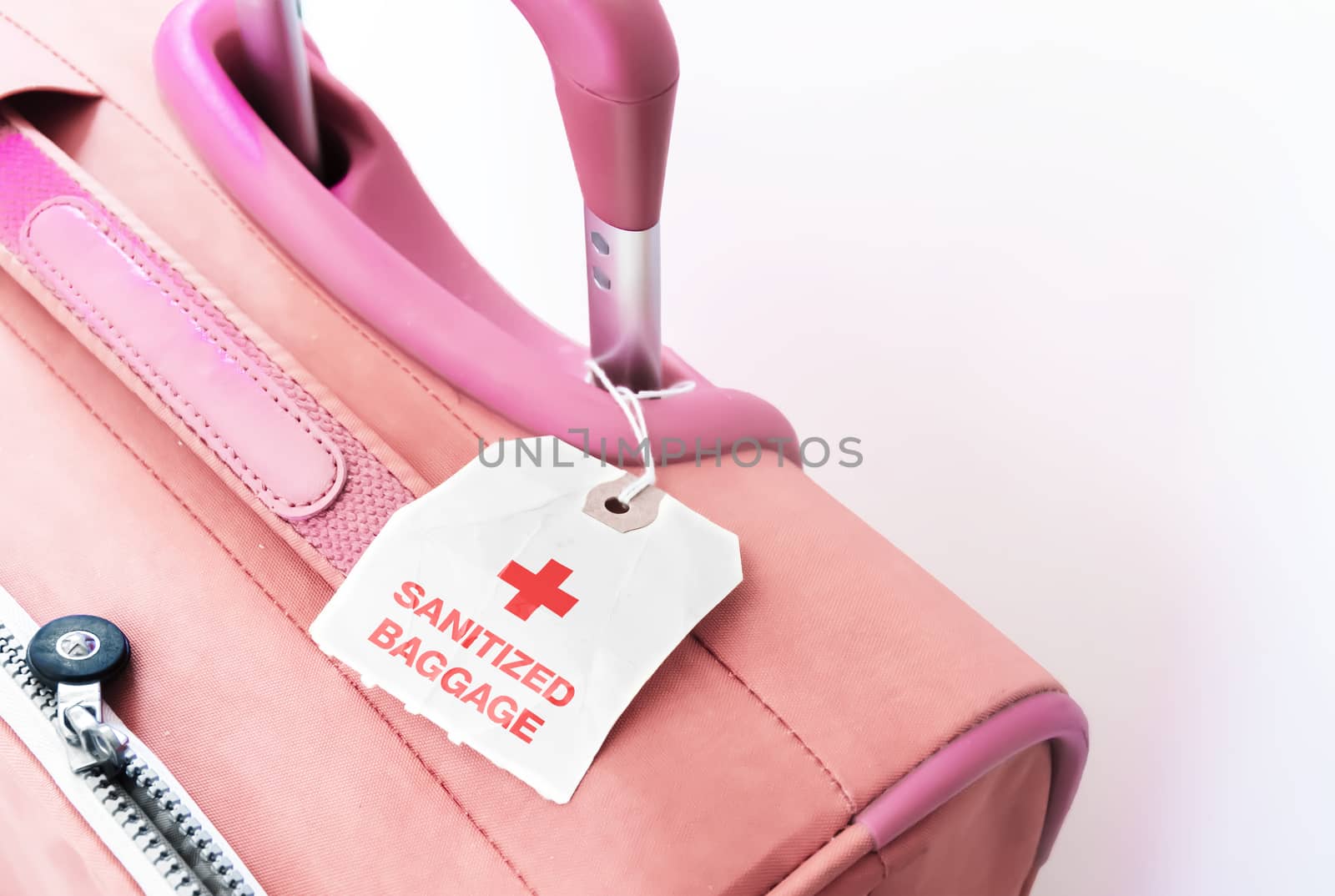 a red suitcase with a paper tag indicating that the baggage has been sanitized. Virus prevention while traveling