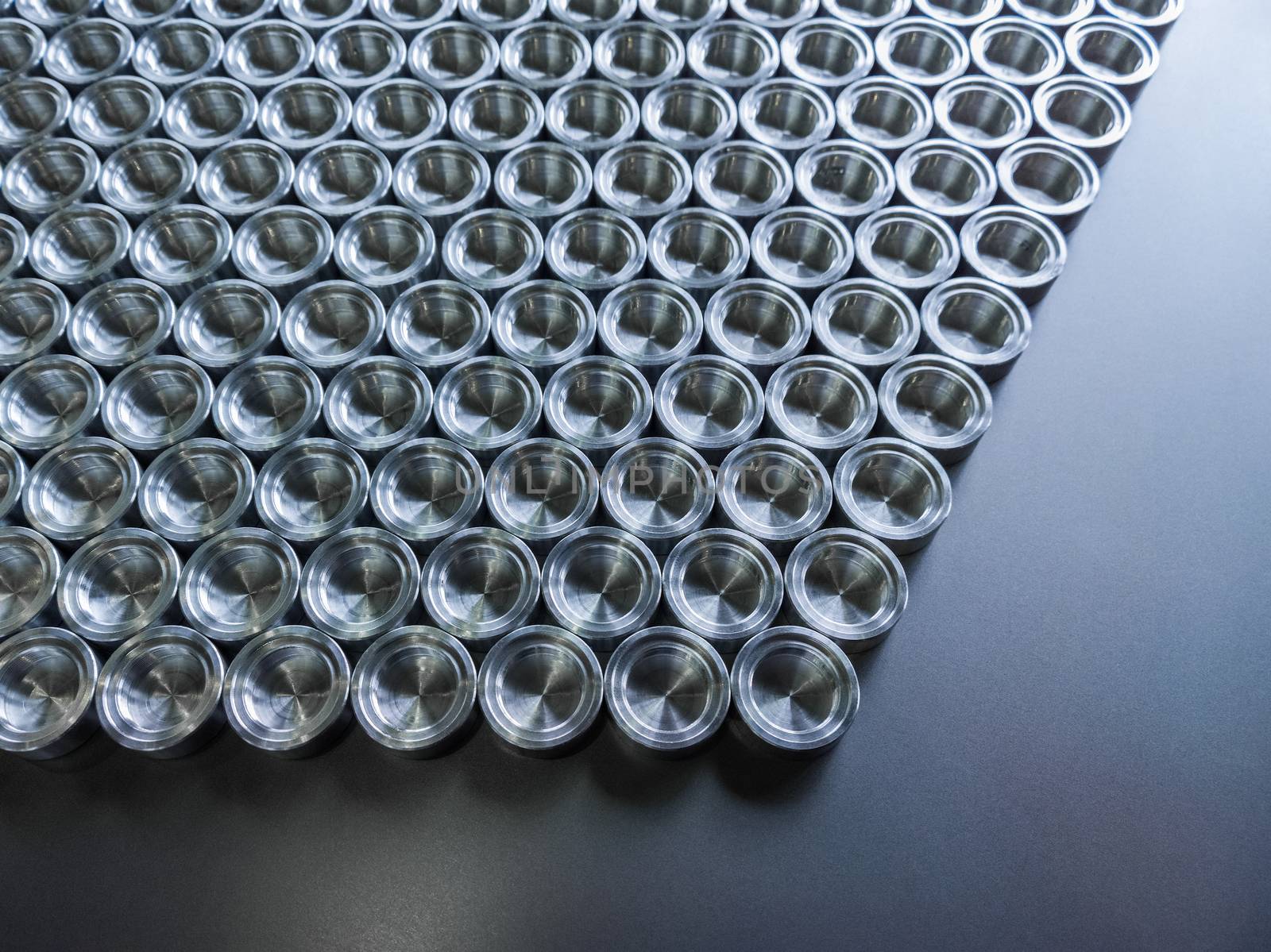Shiny metal parts after cnc turning, on flat surface top-down flat lay background.