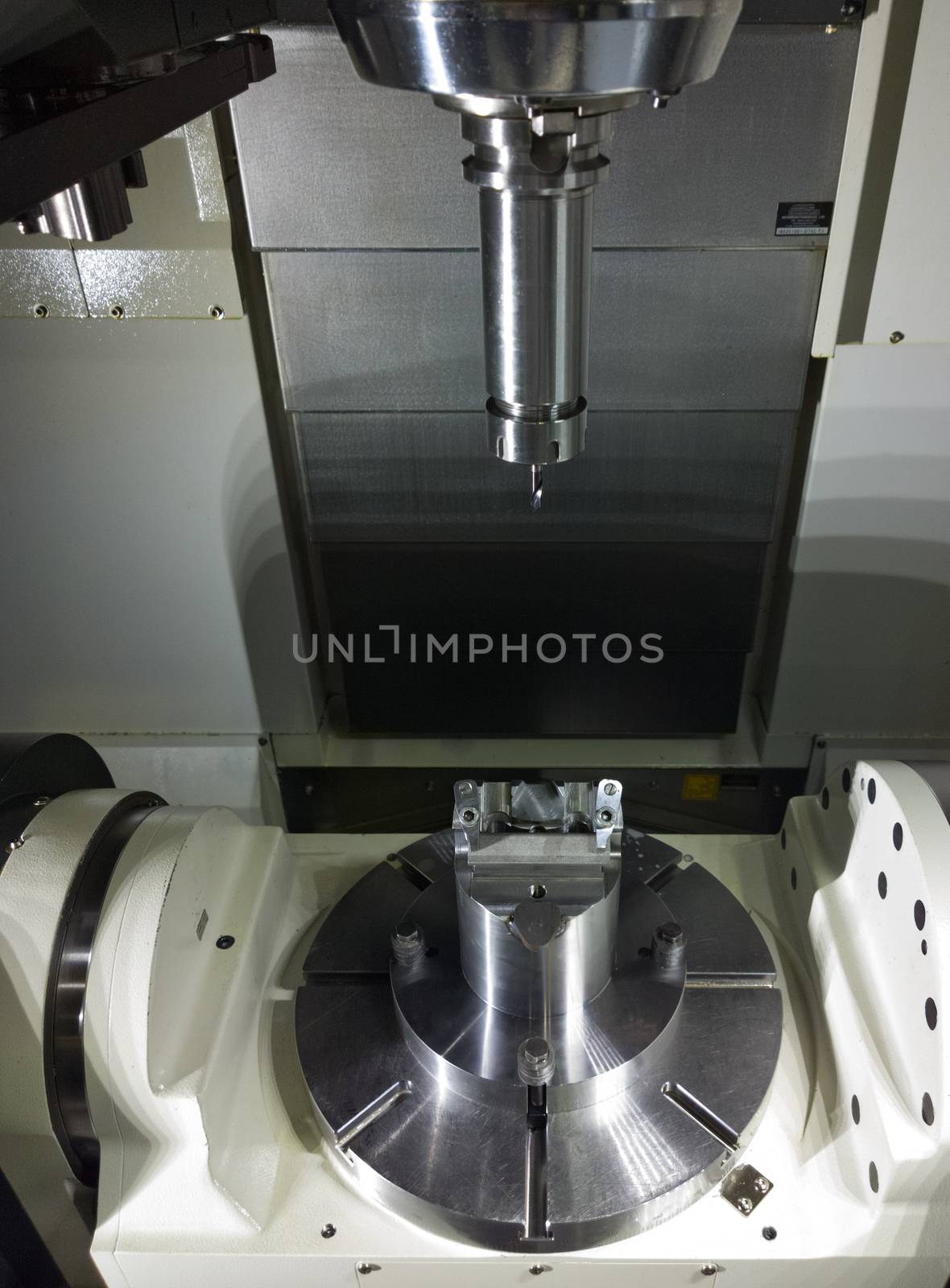The five-axis Computer Numerical Control CNC machine waiting for stock change.