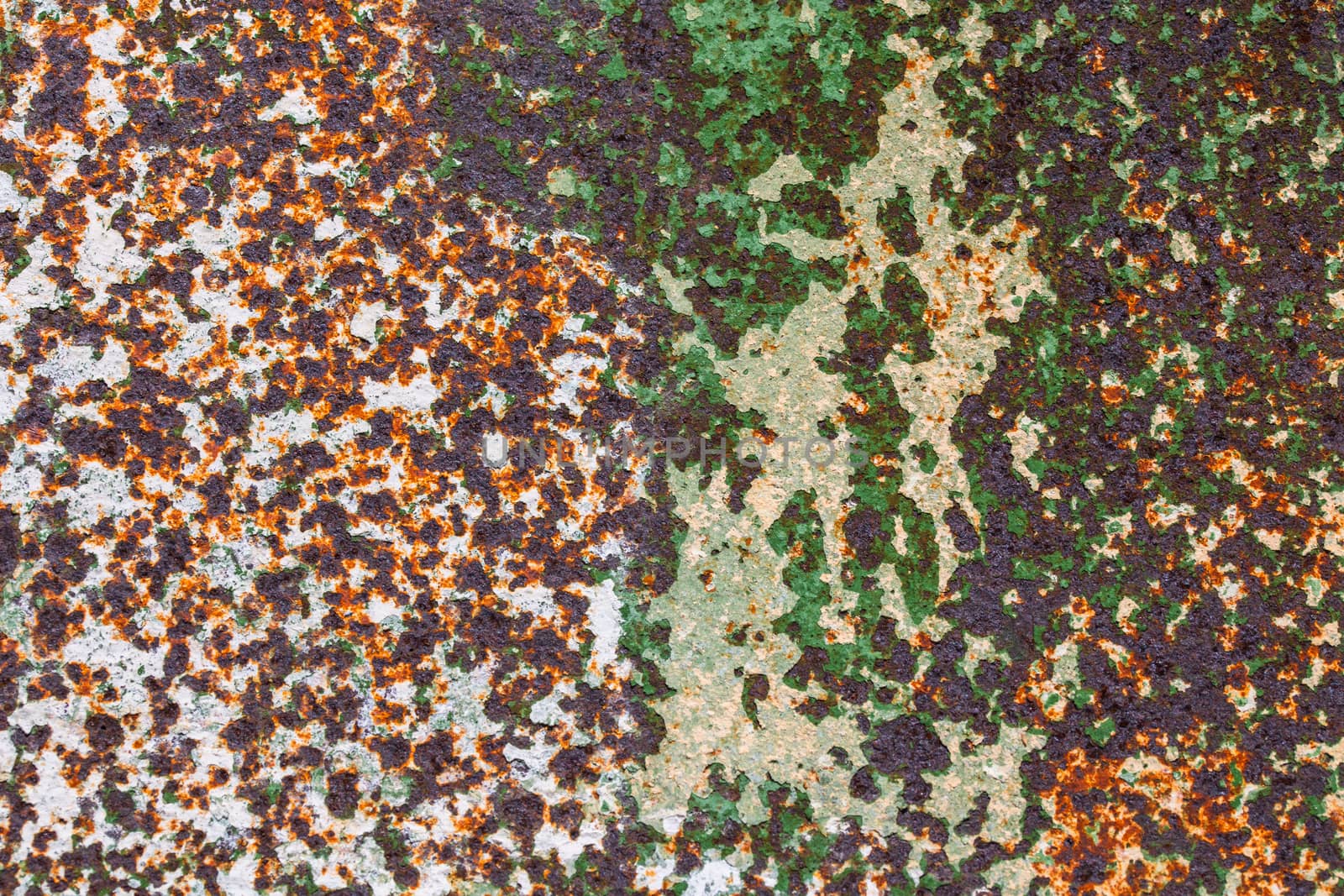 corroded peel paint metal surface background with spots of rust, white and green paint
