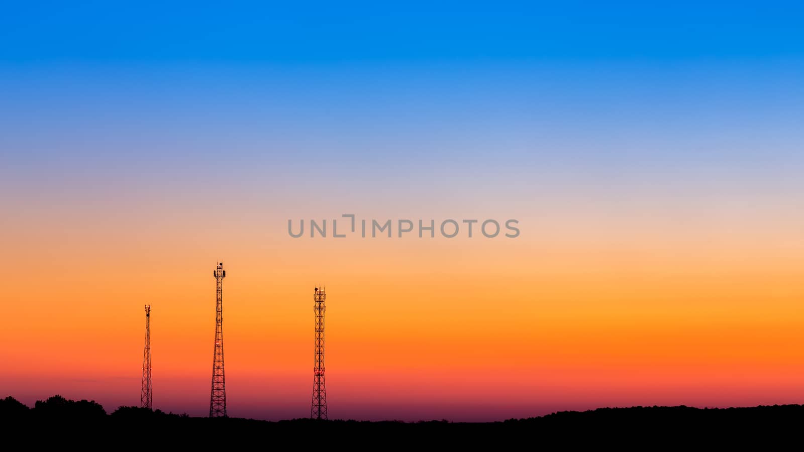 three communication towers far on gradient sunrise sky background with large copyspace