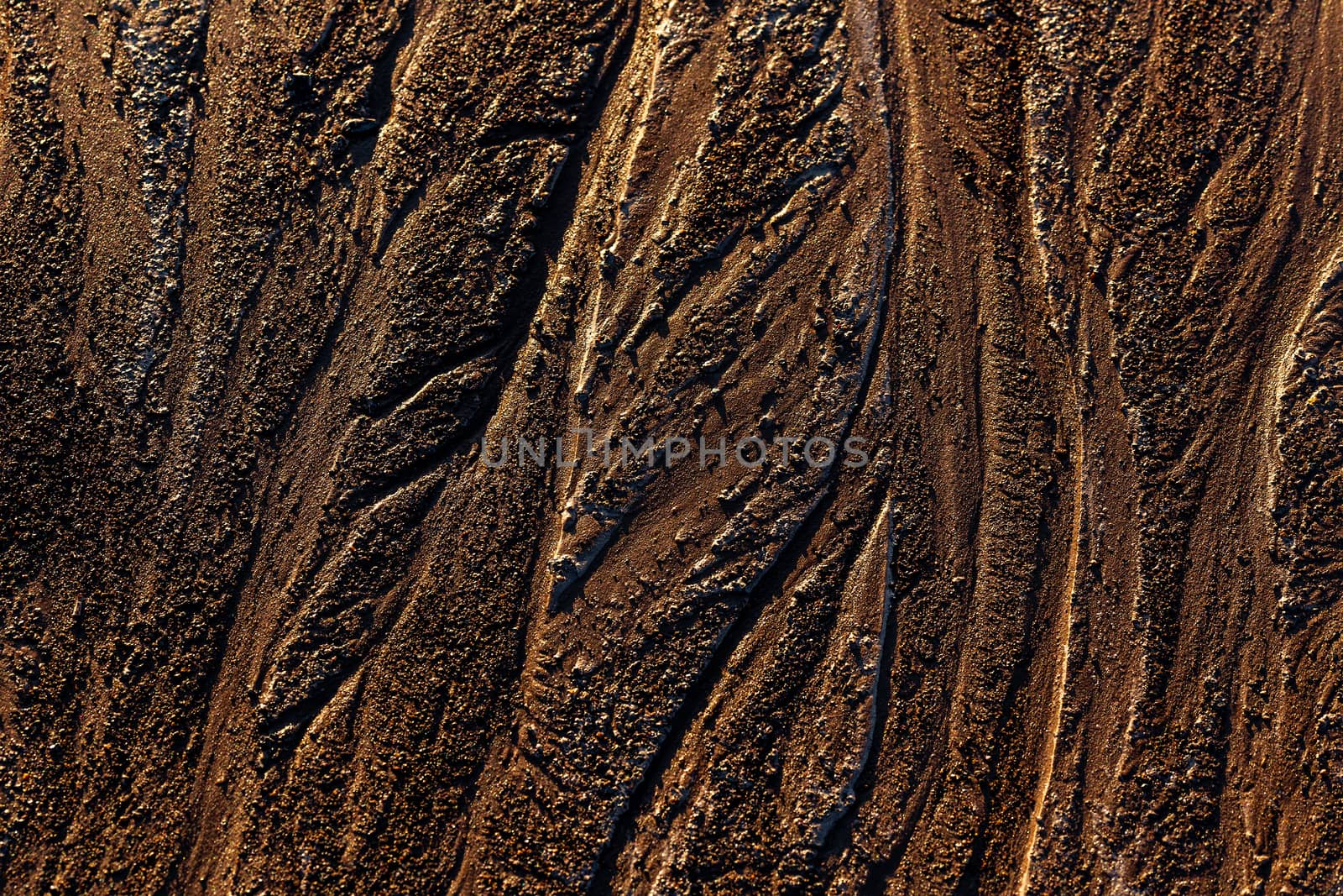 abstract mud background with water washout trails and selective focus.